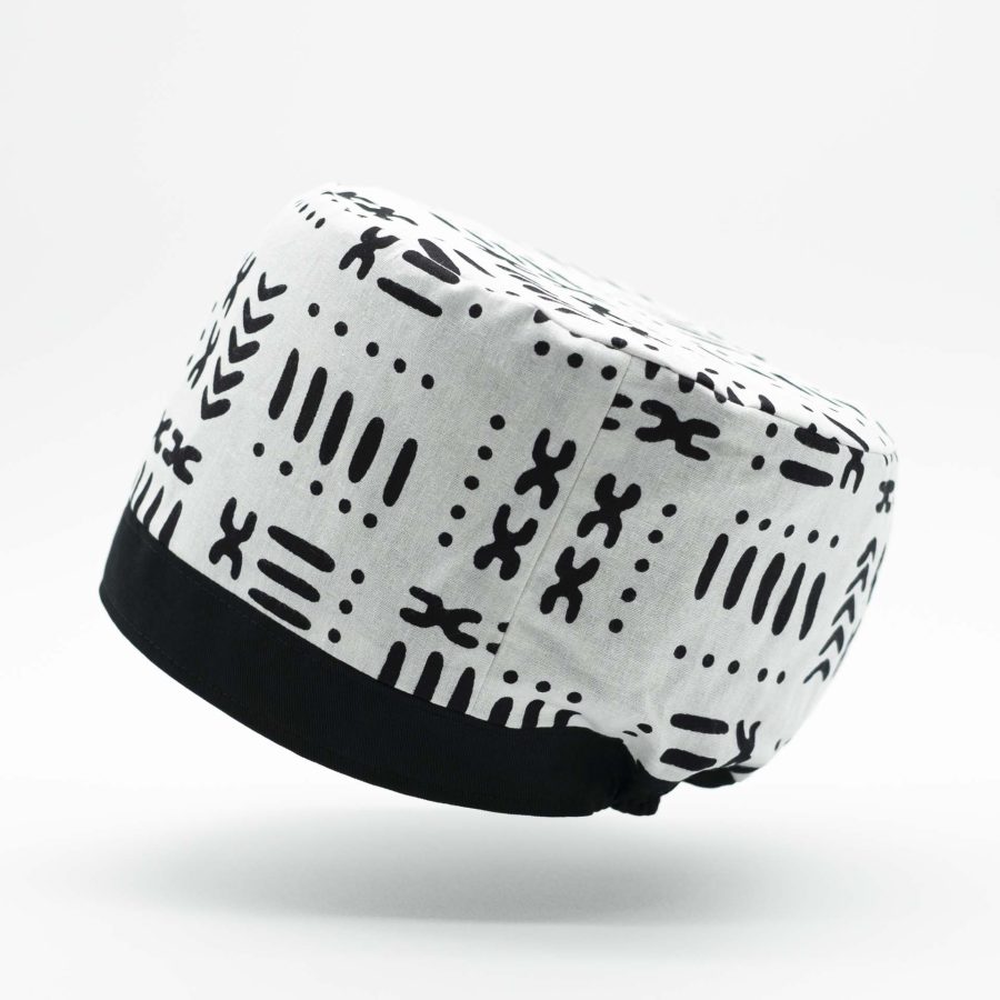 Traditional Rasta hat for dreadlocks in white African wax with modern black patterns with a black cotton headband at the bottom of the hat with black cotton lining