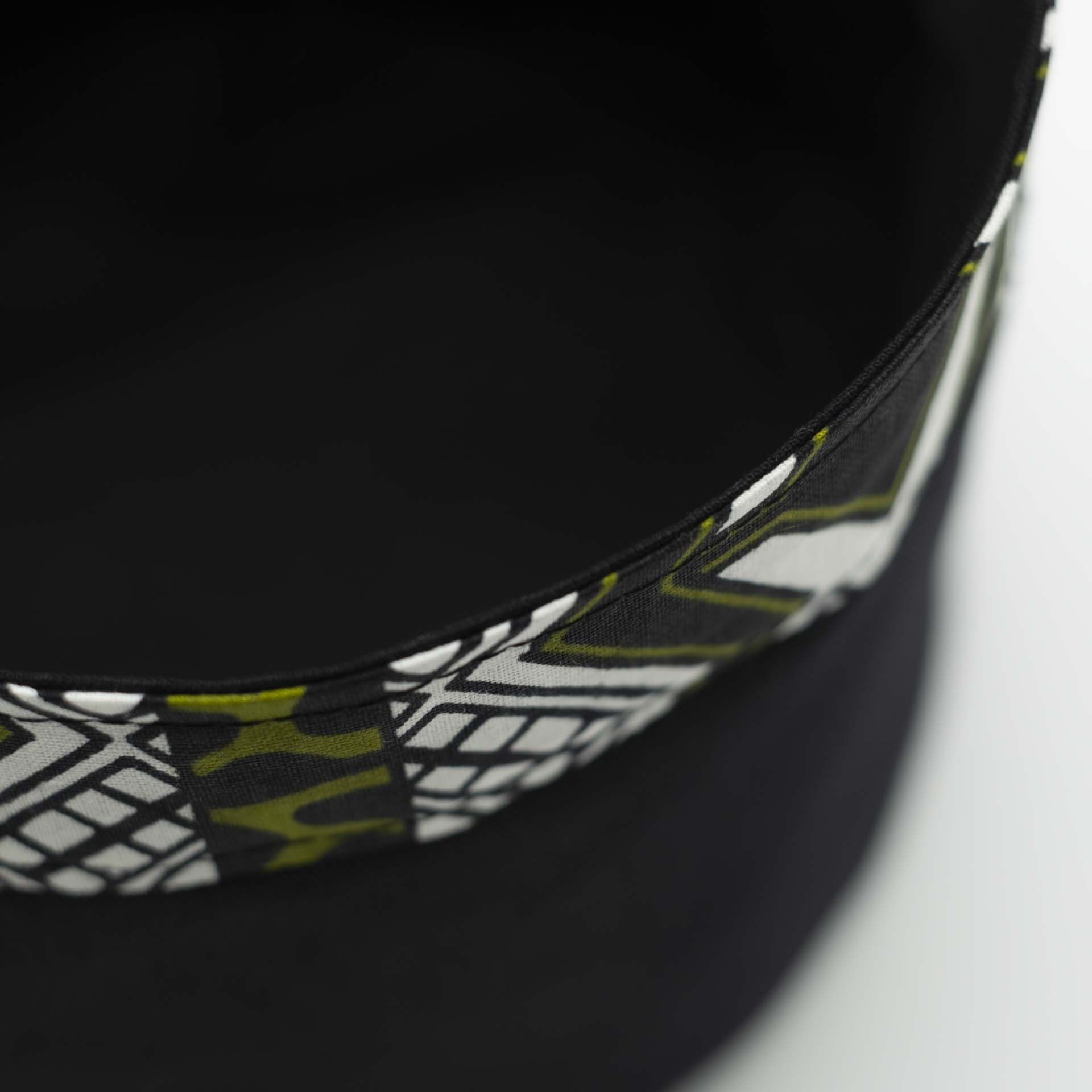 Traditional Rasta hat for dreadlocks in black cotton with ethnic motifs accompanied by a thin colored headband in wax cotton on the bottom of the hat with black lining