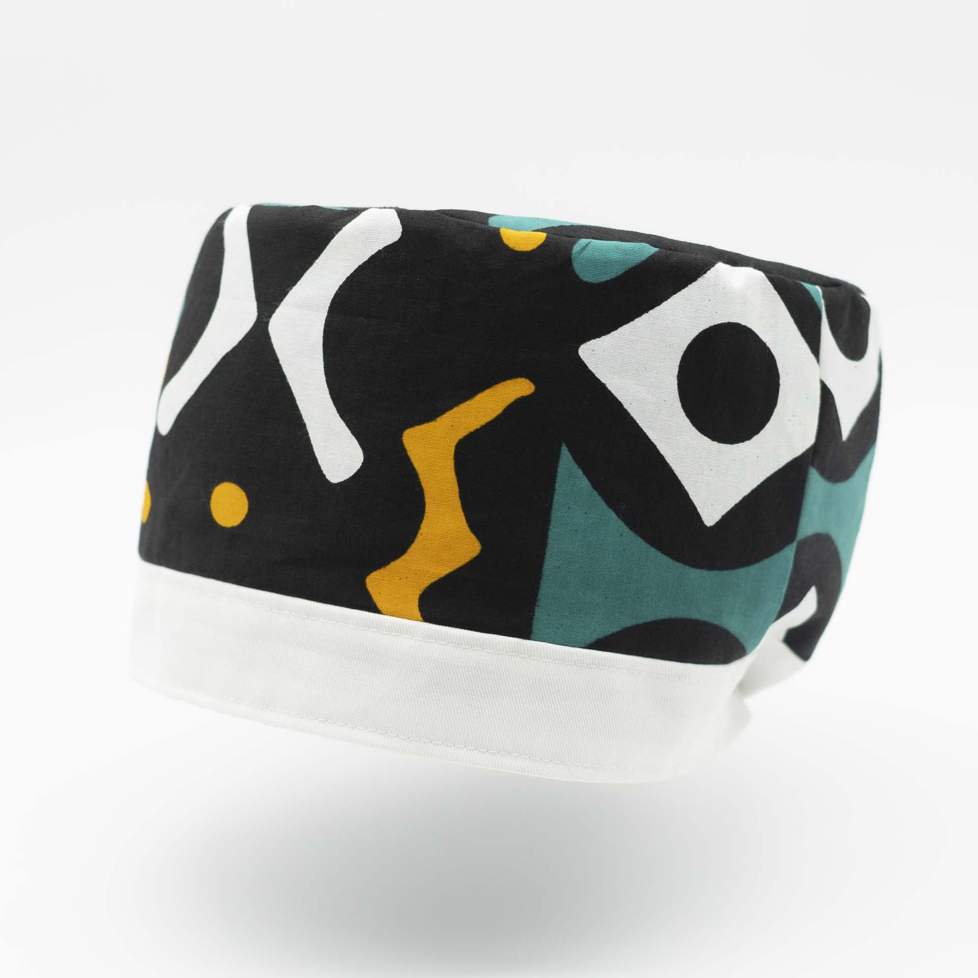 Chapeau Rasta traditionnel pour dreadlocks en wax Africain coloré aux motifs moderne vert blanc et jaune sur fond noir avec un bandeau en coton blanc en bas du chapeau doublure noir