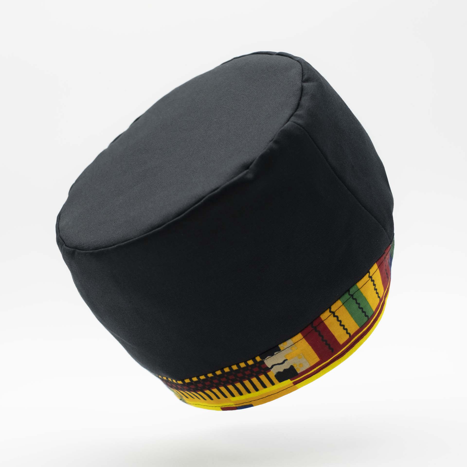 Chapeau Rasta traditionnel pour dreadlocks en coton noir accompagné d'un fin bandeau coloré en coton wax du Ghana sur le bas du chapeau doublure noir