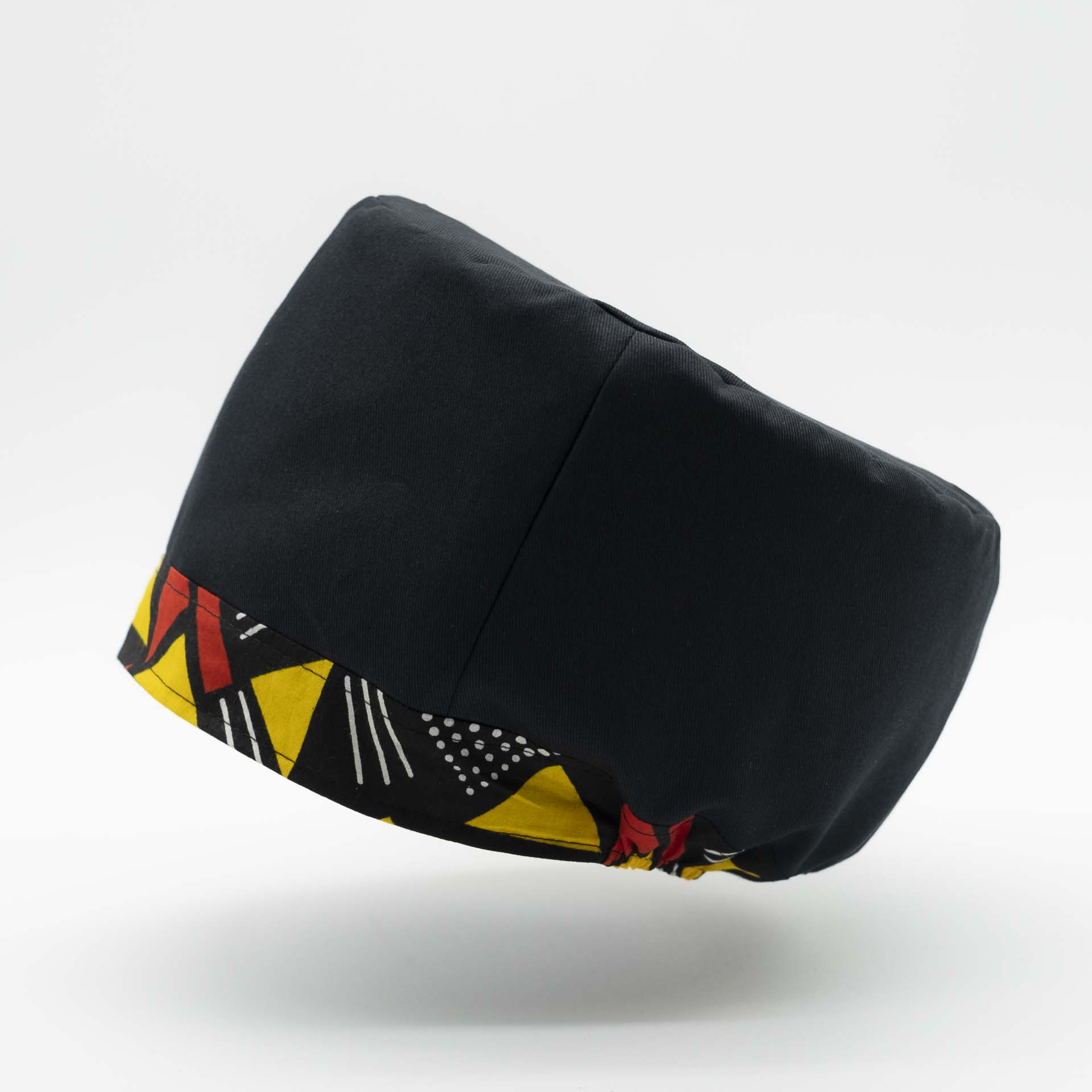 Traditional Rasta hat for dreadlocks in black cotton accompanied by a thin yellow and red colored headband in African wax cotton on the bottom of the hat with black lining