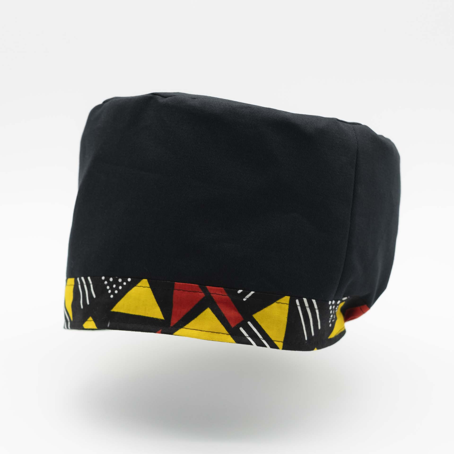 Traditional Rasta hat for dreadlocks in black cotton accompanied by a thin yellow and red colored headband in African wax cotton on the bottom of the hat with black lining