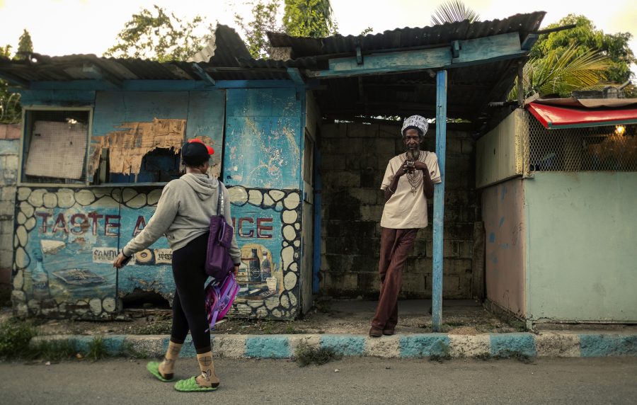 Ancien Rastaman dans les rues de Kingston portant un chapeau pour dreadlocks en wax blanc