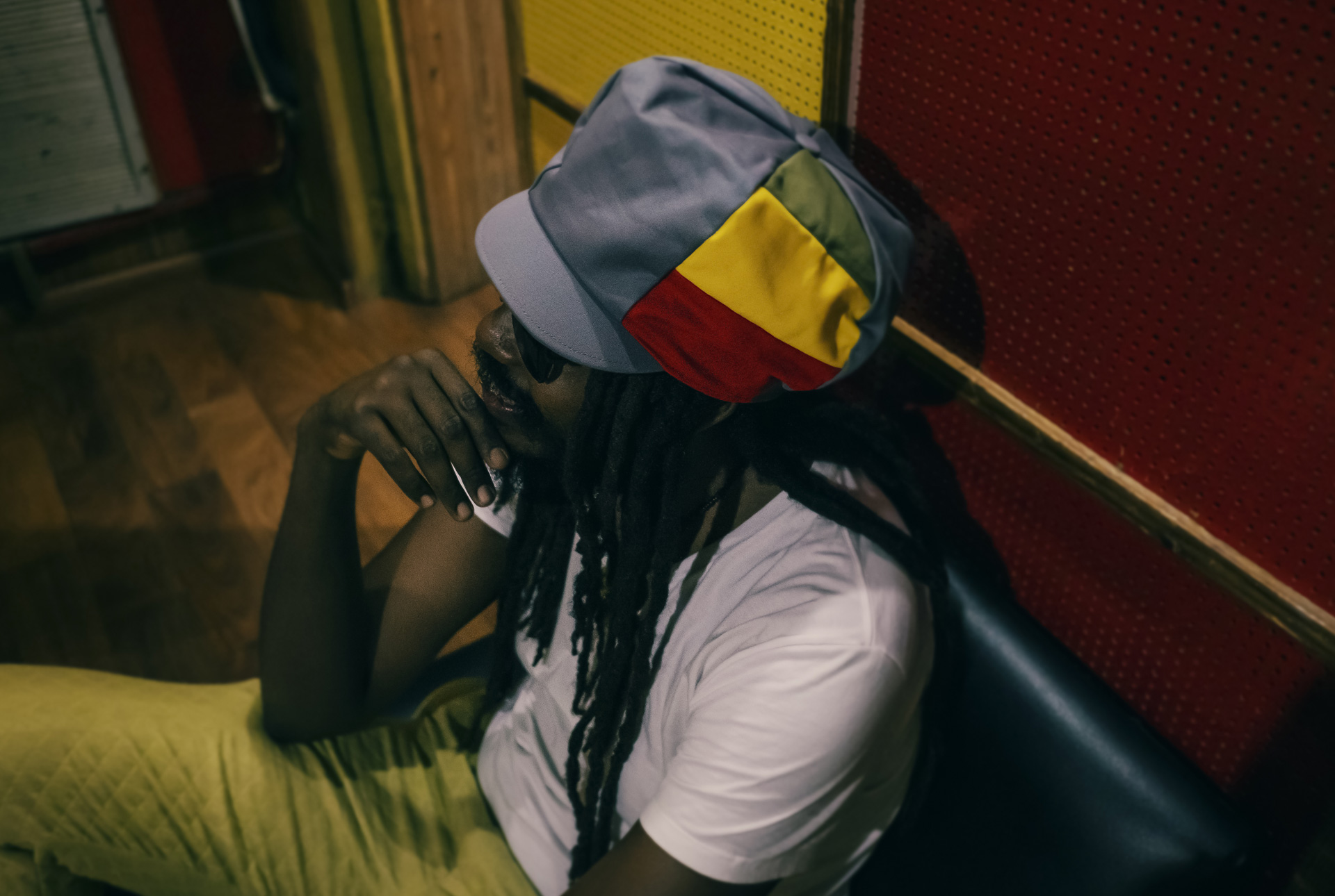 Bassiste Jamaïcain à Tuff Gong Studio portant un magnifique chapeau pour dreadlocks gris en coton avec un pan vert jaune rouge