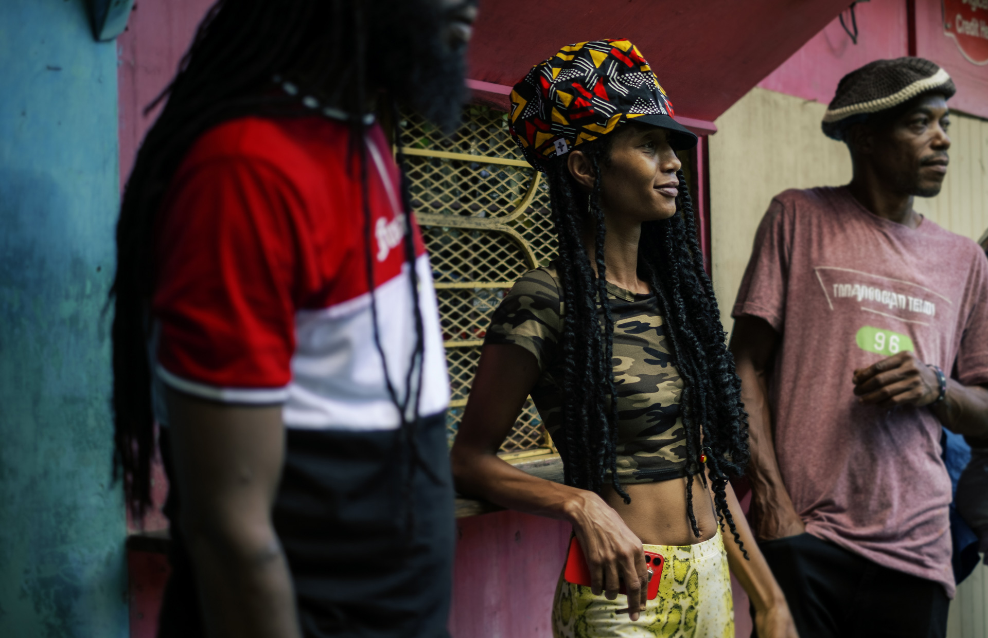 Jeune Jamaïcaine devant un shop arborant un gros chapeau pour Dreadlocks coloré