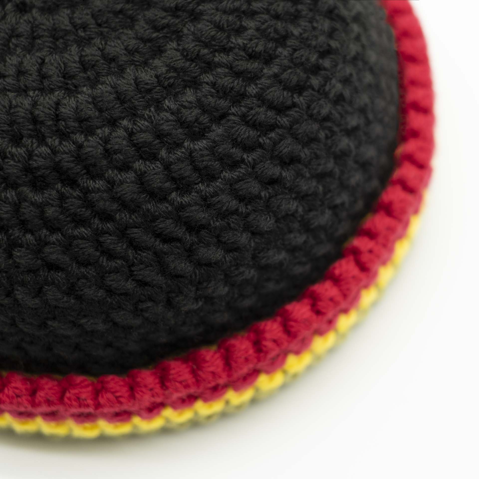 Beanie wool hat in black with a thin green yellow red hem