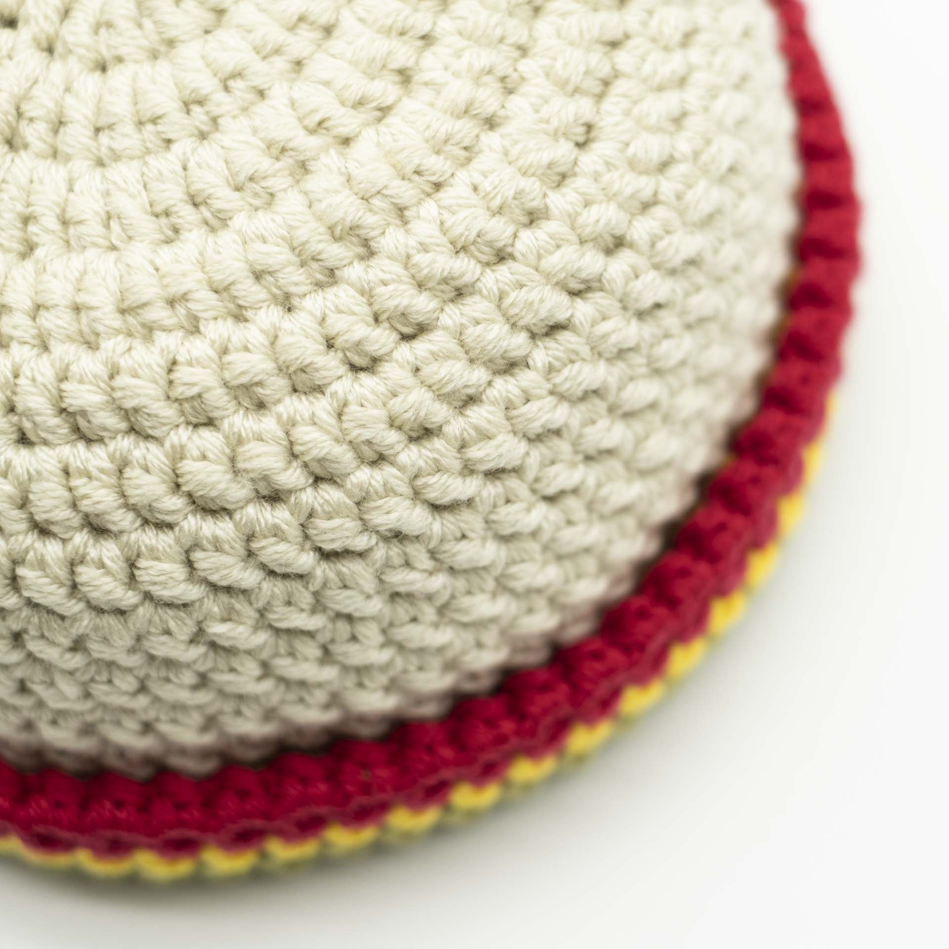 Bonnet en laine style marin de couleur crème avec un ourlet fin vert jaune rouge