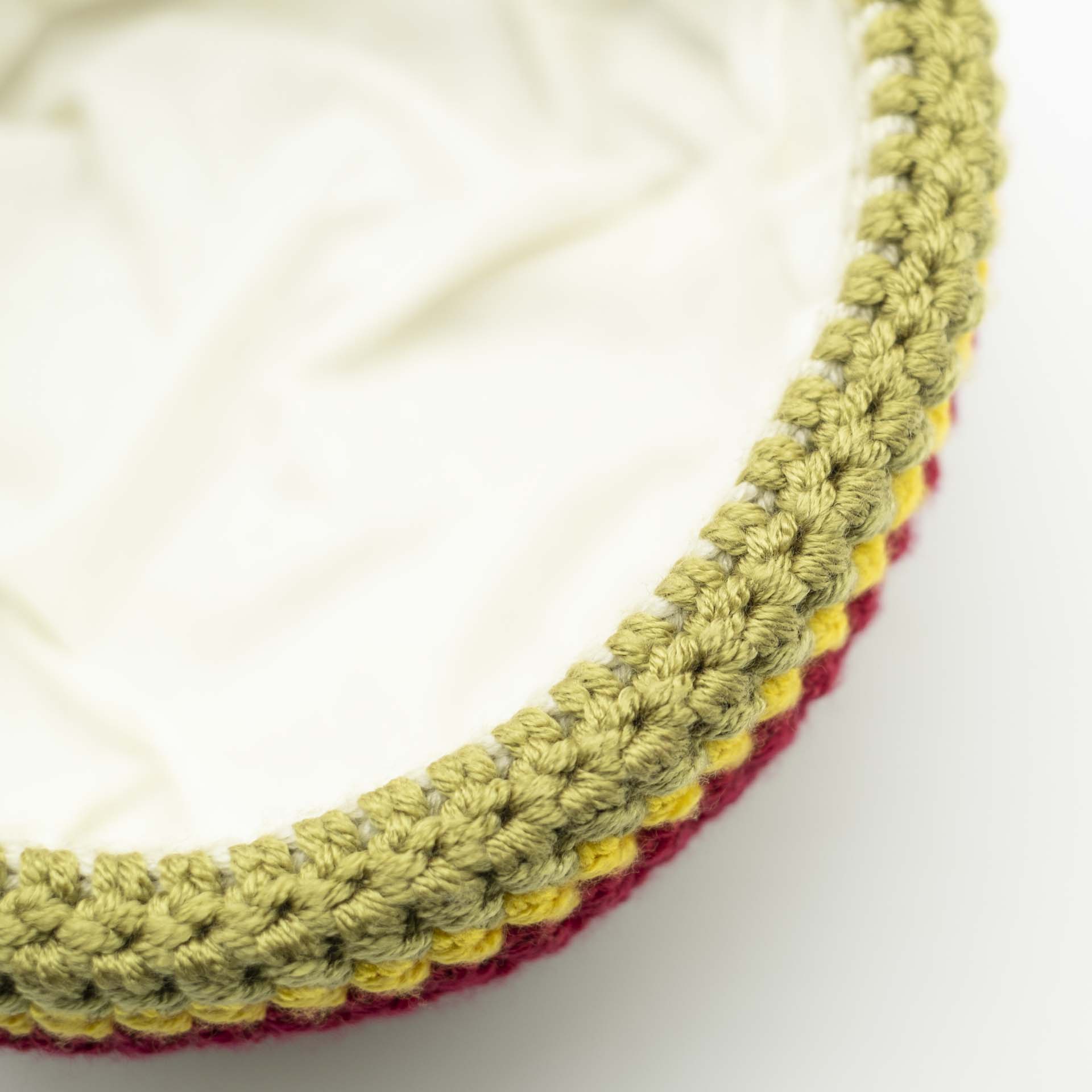 Bonnet en laine style marin de couleur crème avec un ourlet fin vert jaune rouge