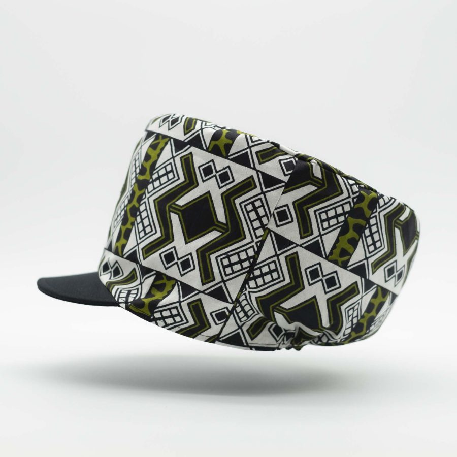 Rasta hat with black visor in light wax fabric with white and green ethnic patterns, black lining