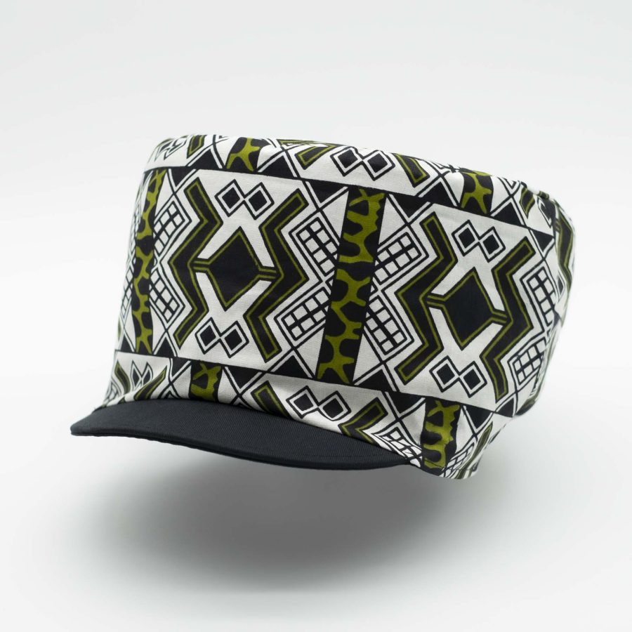 Rasta hat with black visor in light wax fabric with white and green ethnic patterns, black lining