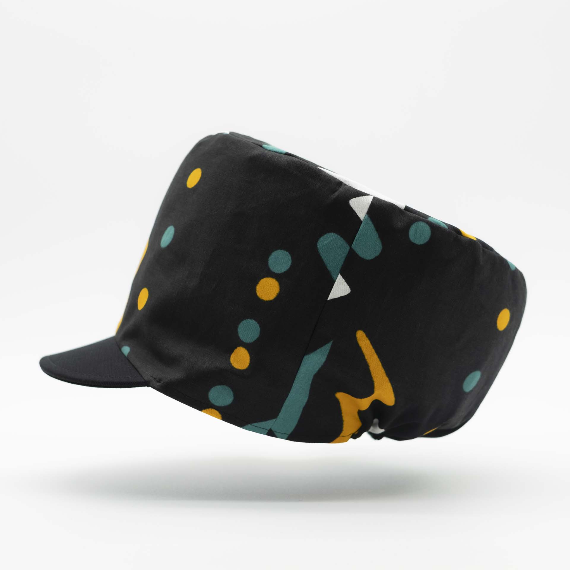 Rasta dreadlocks hat with visor in light wax fabric with ethnic white yellow and green patterns on a black background black lining