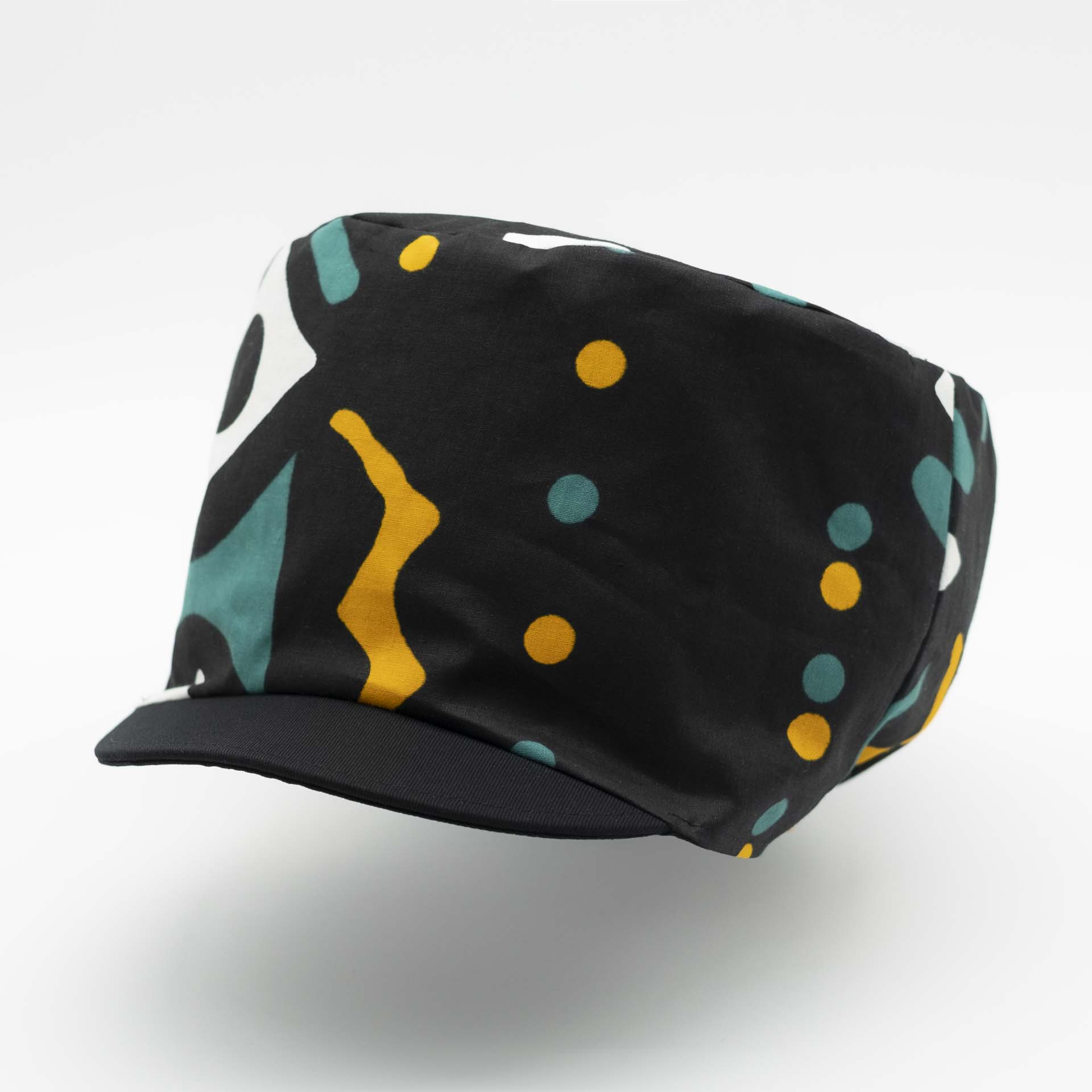 Rasta dreadlocks hat with visor in light wax fabric with ethnic white yellow and green patterns on a black background black lining