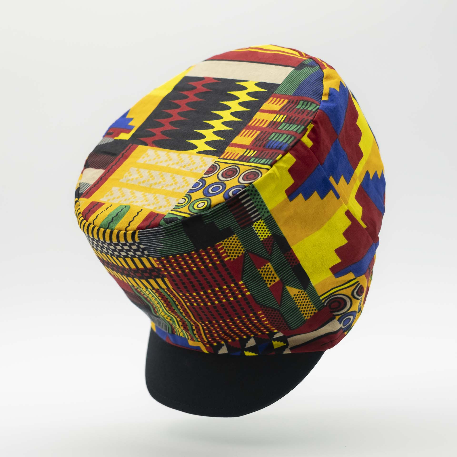 Rasta dreadlocks hat with black visor in light wax fabric with colorful African patterns black lining