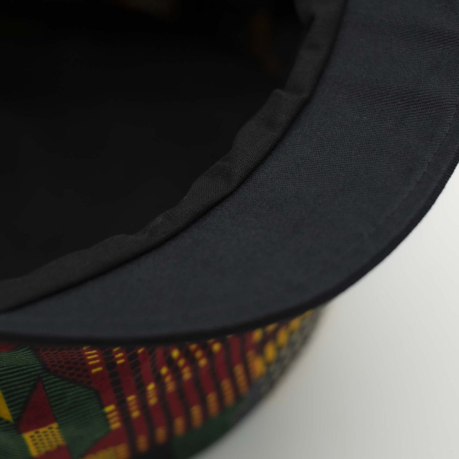 Rasta dreadlocks hat with black visor in light wax fabric with colorful African patterns black lining