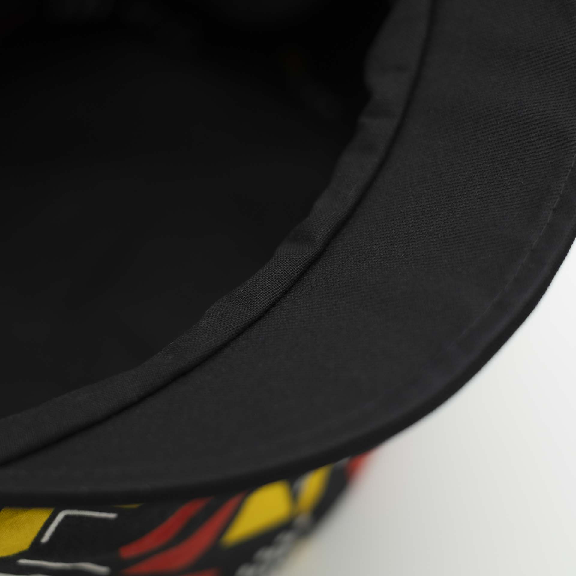 Casquette Rasta dreadlocks avec visière noir en tissu léger wax aux motifs coloré géométrique rouge et jaune doublure noir