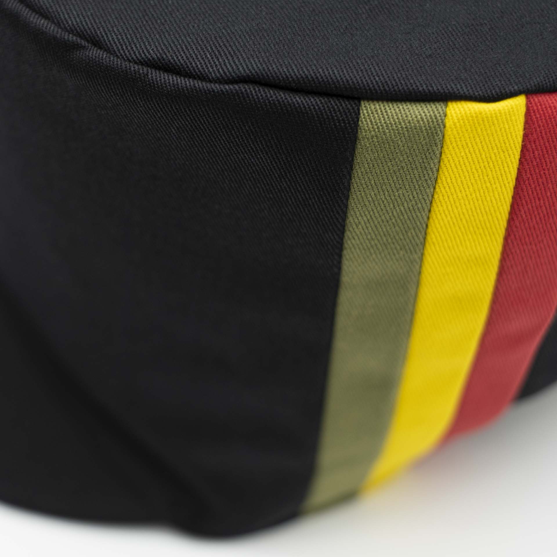 Chapeau Rasta pour dreadlocks en coton noir avec trois bandes vert jaune rouge sur un côté du chapeau et doublure noir