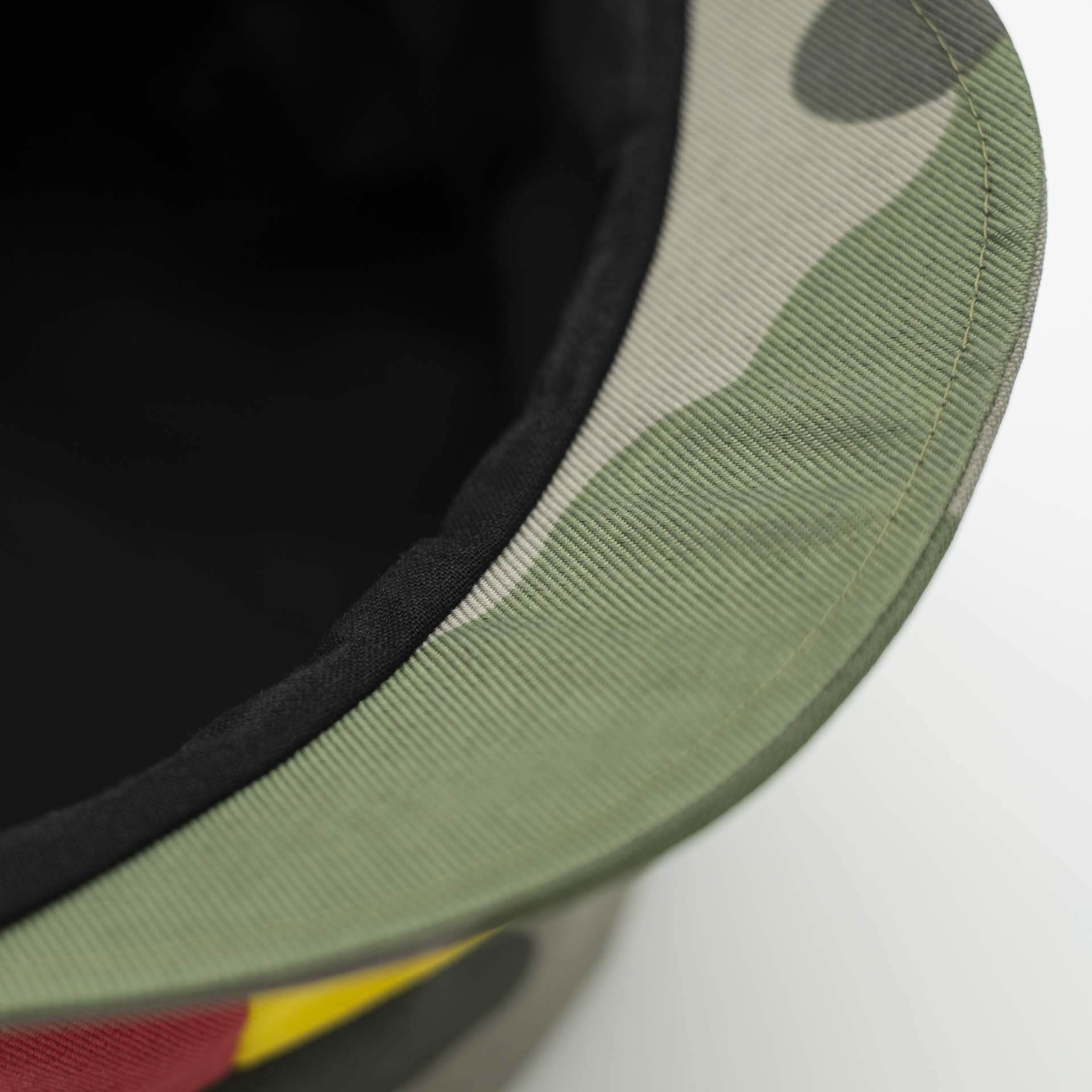 Chapeau dreadlocks tissu camouflage militaire avec un pan vert jaune rouge sur la face avant du chapeau doublure noir