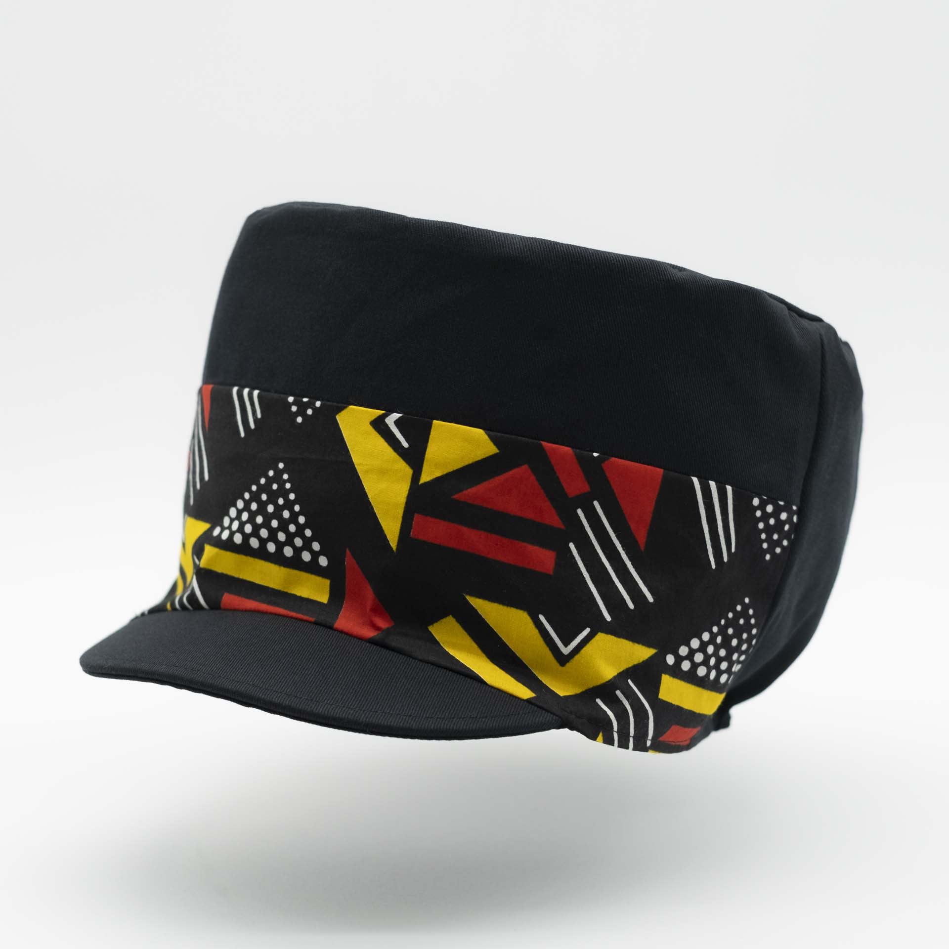 Rasta cap with dreadlocks in black cotton with a front pant facing in wax with yellow and red geometric patterns, black lining