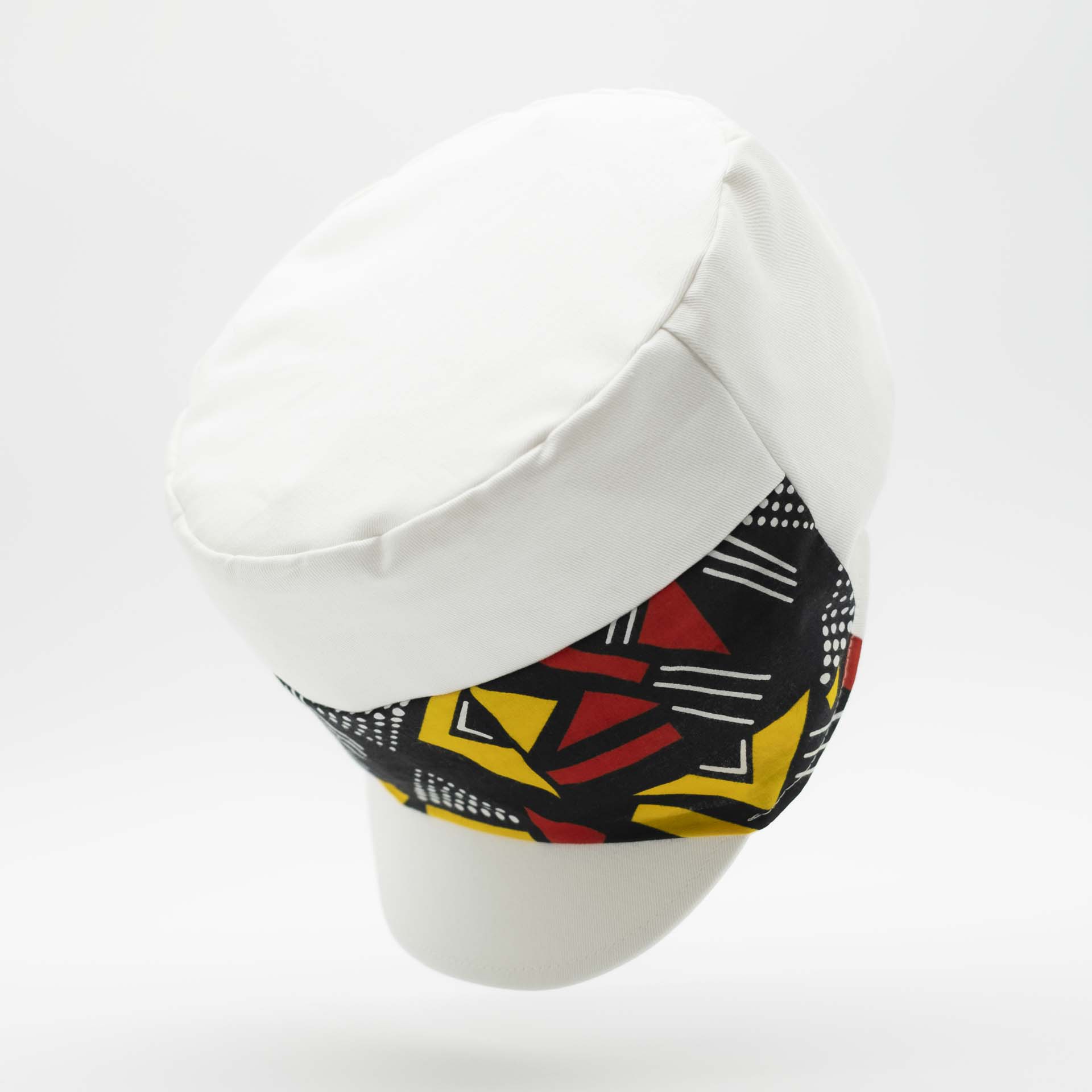 Rasta cap with dreadlocks in white cotton with a front pant facing in yellow and red geometric pattern wax with white lining