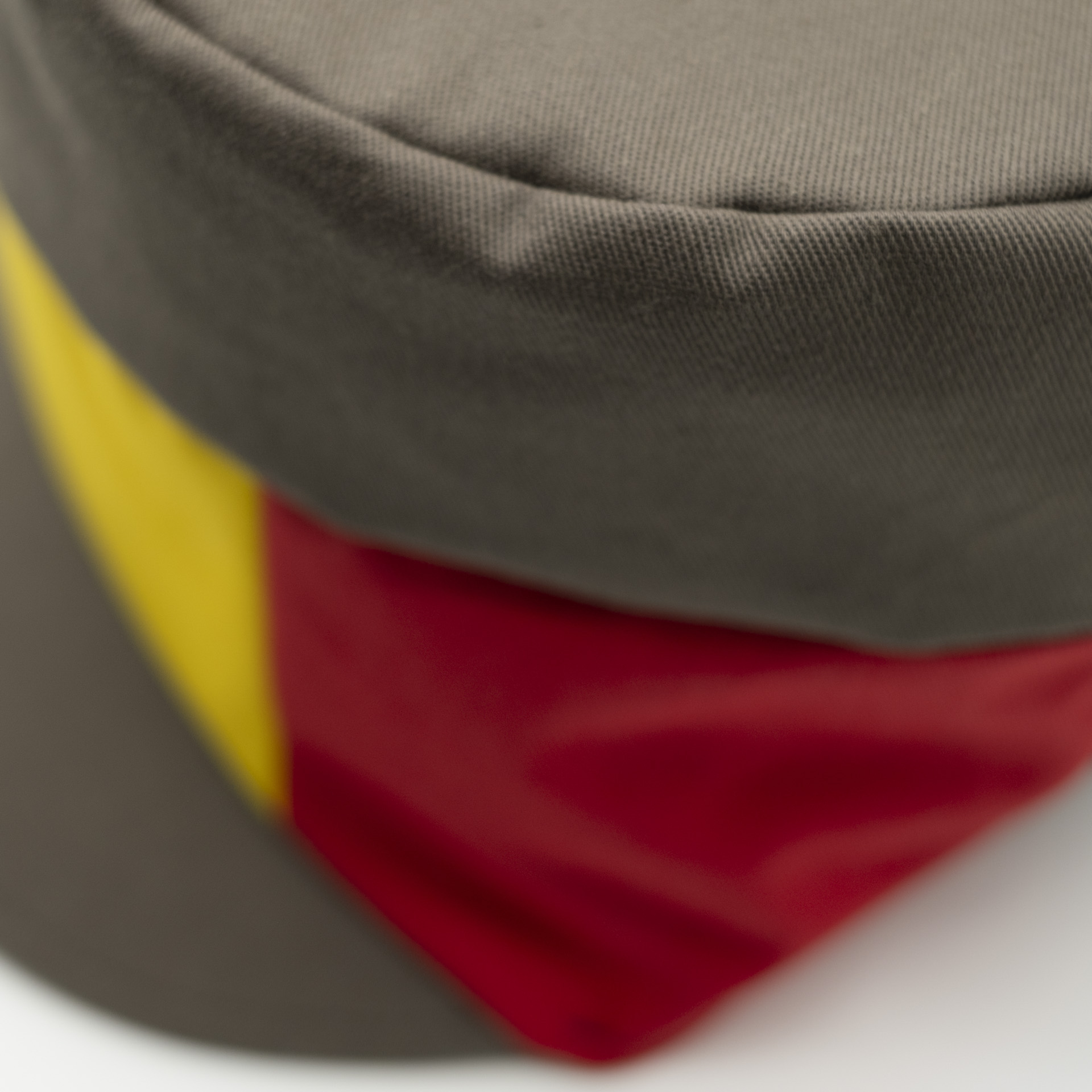 Dreadlocks hat crown with visor in brown fabric with a red yellow green panel on the front and a raw lining