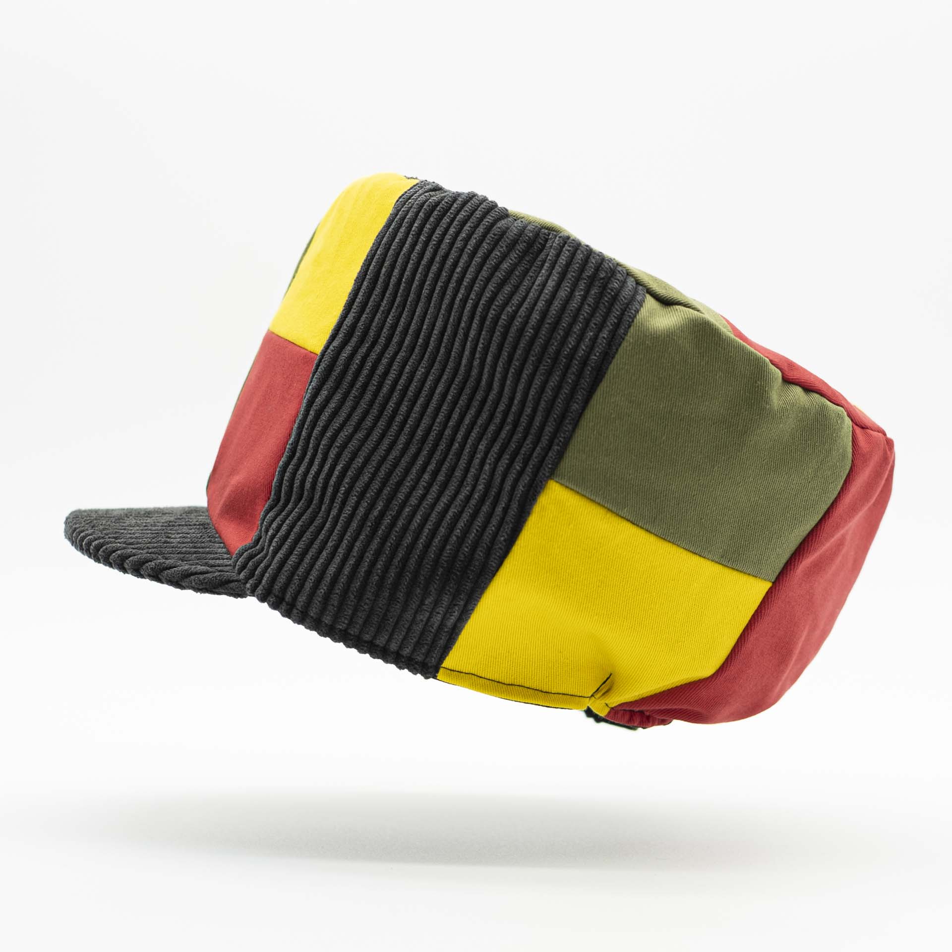 Casquette Rasta avec visière conçu avec un assemblage de pièce de velours côtelé et de coton effet déstructuré pour dreadlocks noir vert jaune rouge