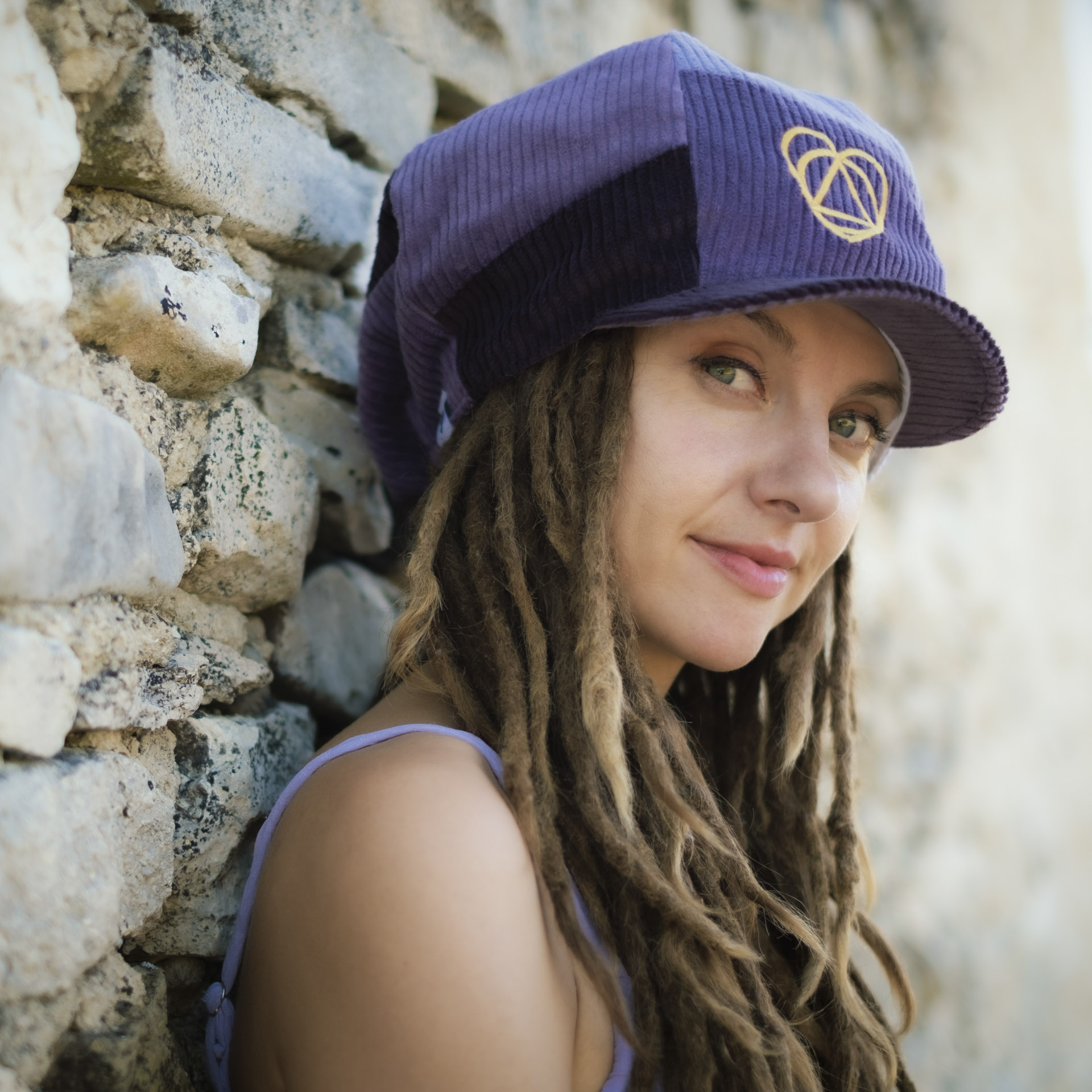 Portrait of reggae artist Lavender Fields wearing a Dreadlocks Nation hat, Lavender Fields Signature Collection, a purple corduroy Rasta newsboy cap with visor for dreadlocks and a white lining
