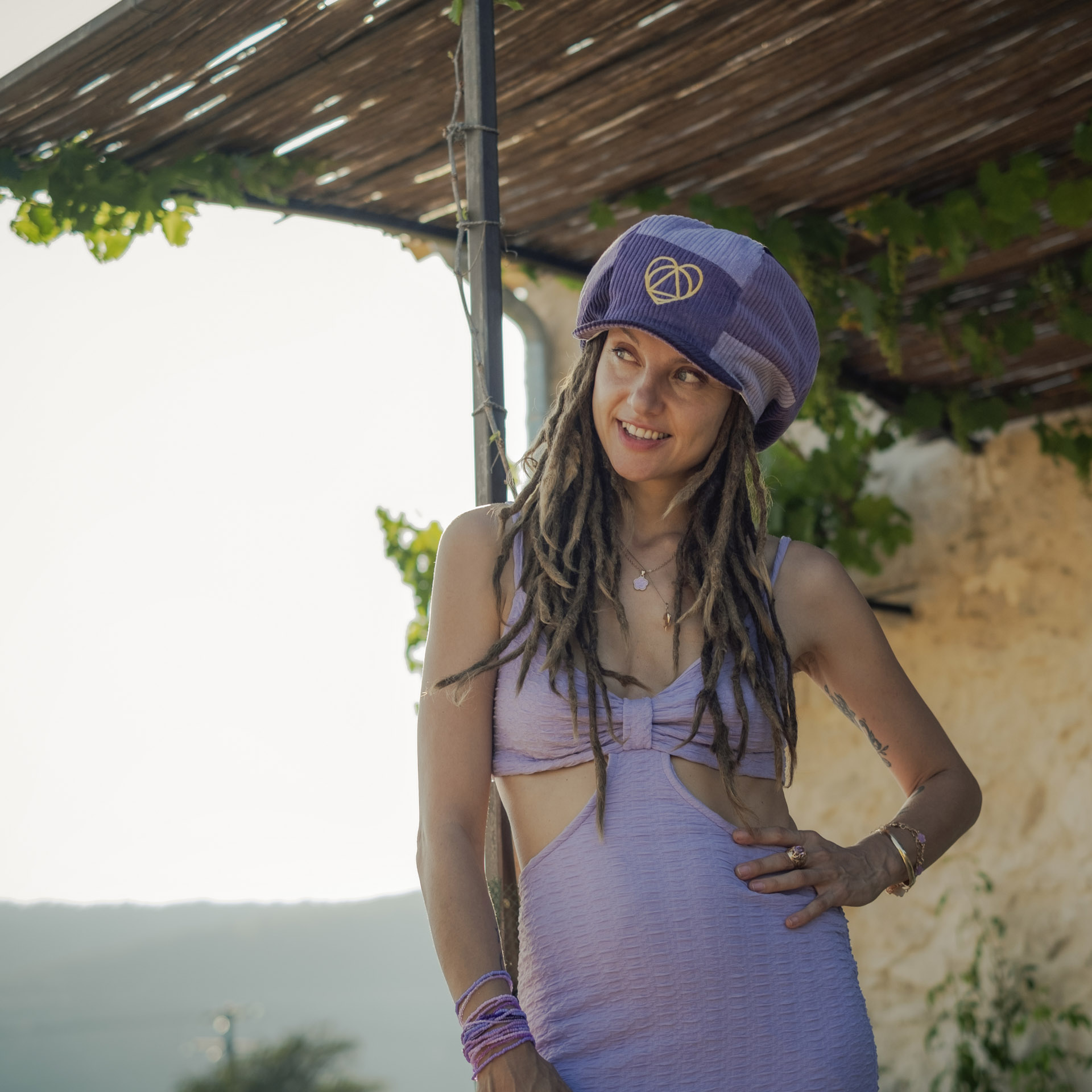 Reggae artist Lavender Fields wearing a Dreadlocks Nation hat, Lavender Fields Signature Collection, a purple corduroy Rasta newsboy cap with visor for dreadlocks and a white lining.