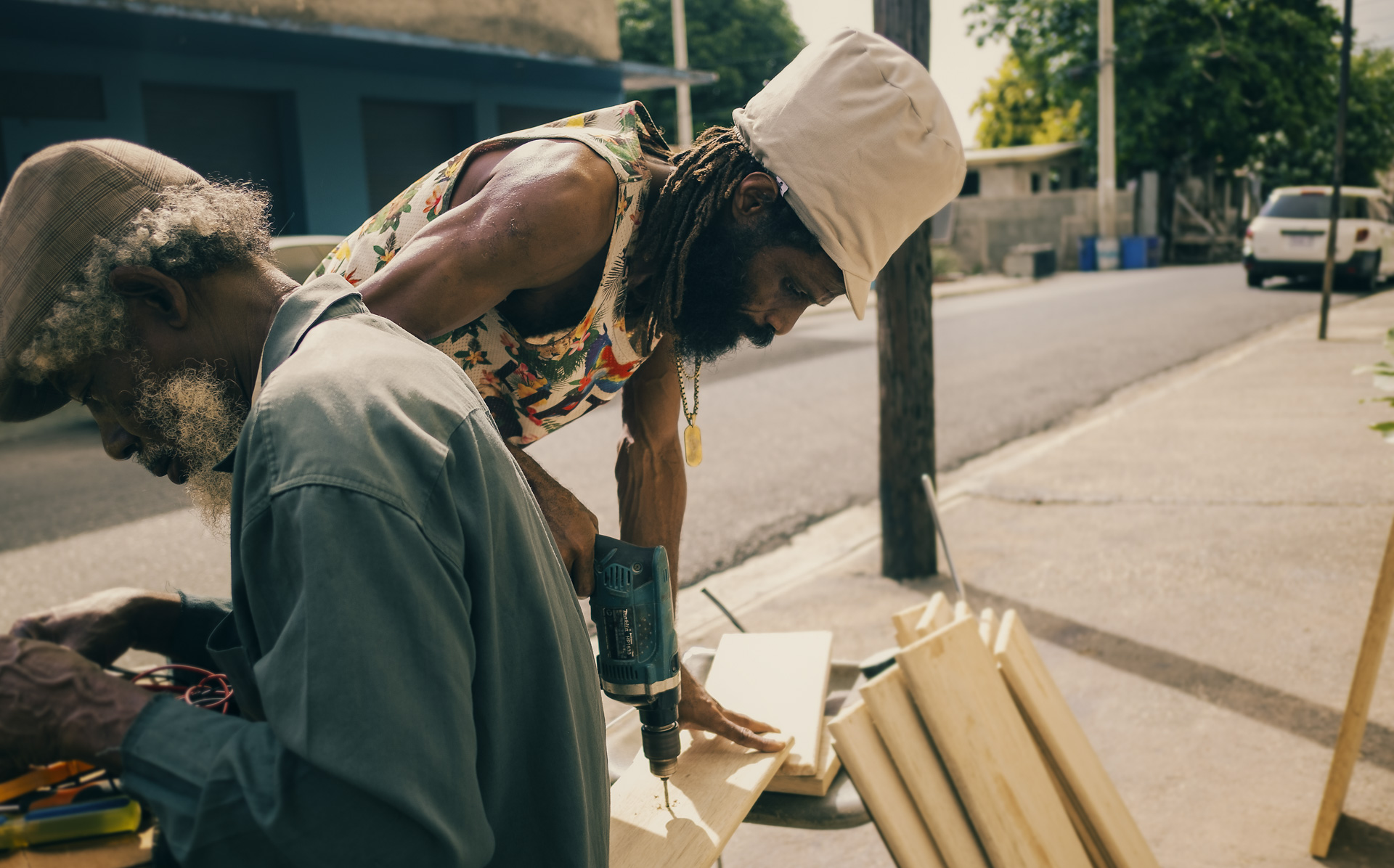 Jamaican Rasta carpenter working in the street with a beige dreadlocks hat