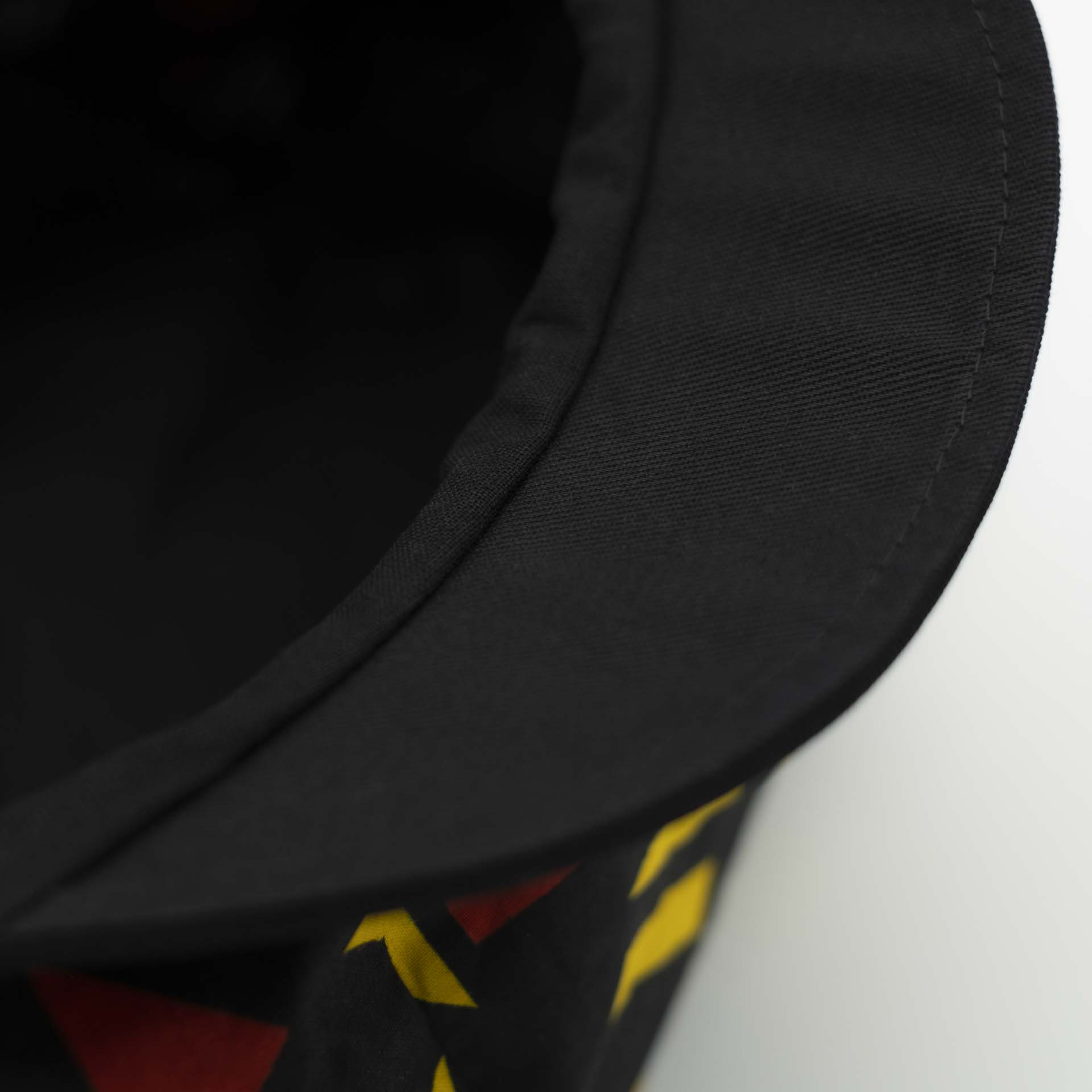 Casquette Rasta gavroche à dreadlocks avec visière noir en tissu léger wax aux motifs coloré géométrique rouge et jaune doublure noir