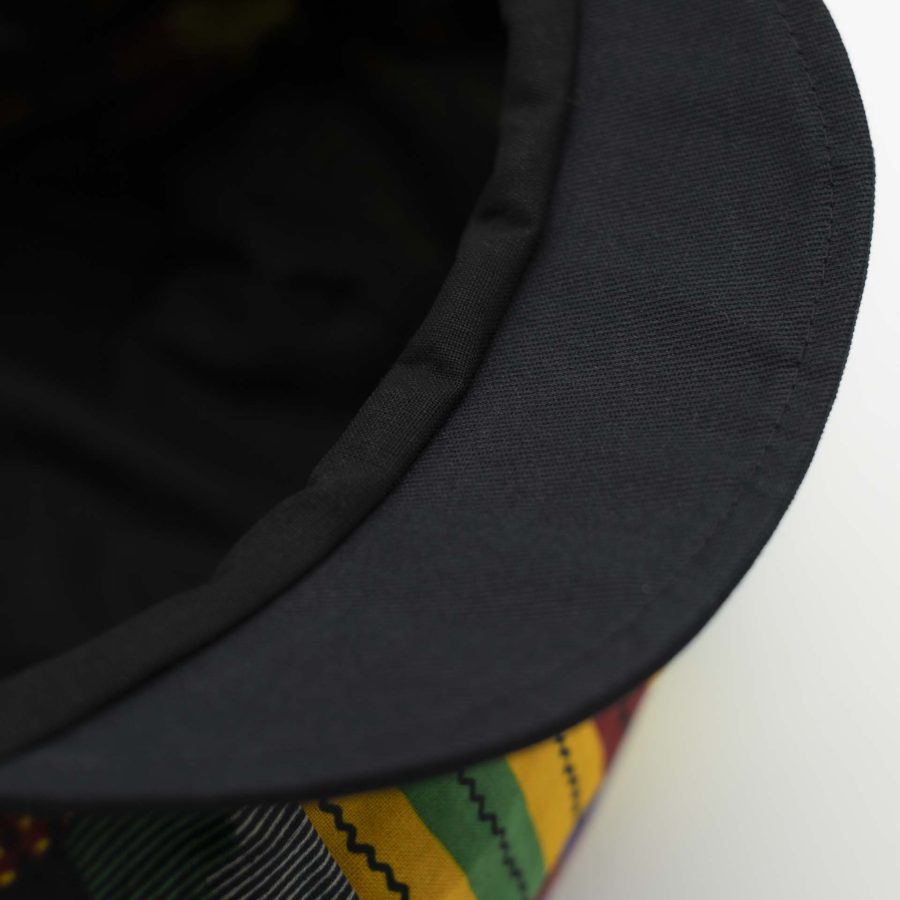 Rasta dreadlocks newsboy cap with black visor in light wax fabric with colorful African patterns, black lining