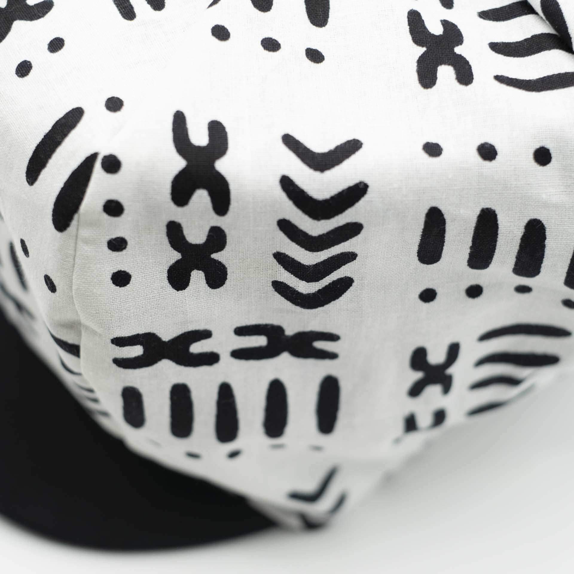 Casquette Rasta gavroche dreadlocks avec visière noir en tissu léger wax aux motifs ethnique Africain noir sur fond blanc doublure noir