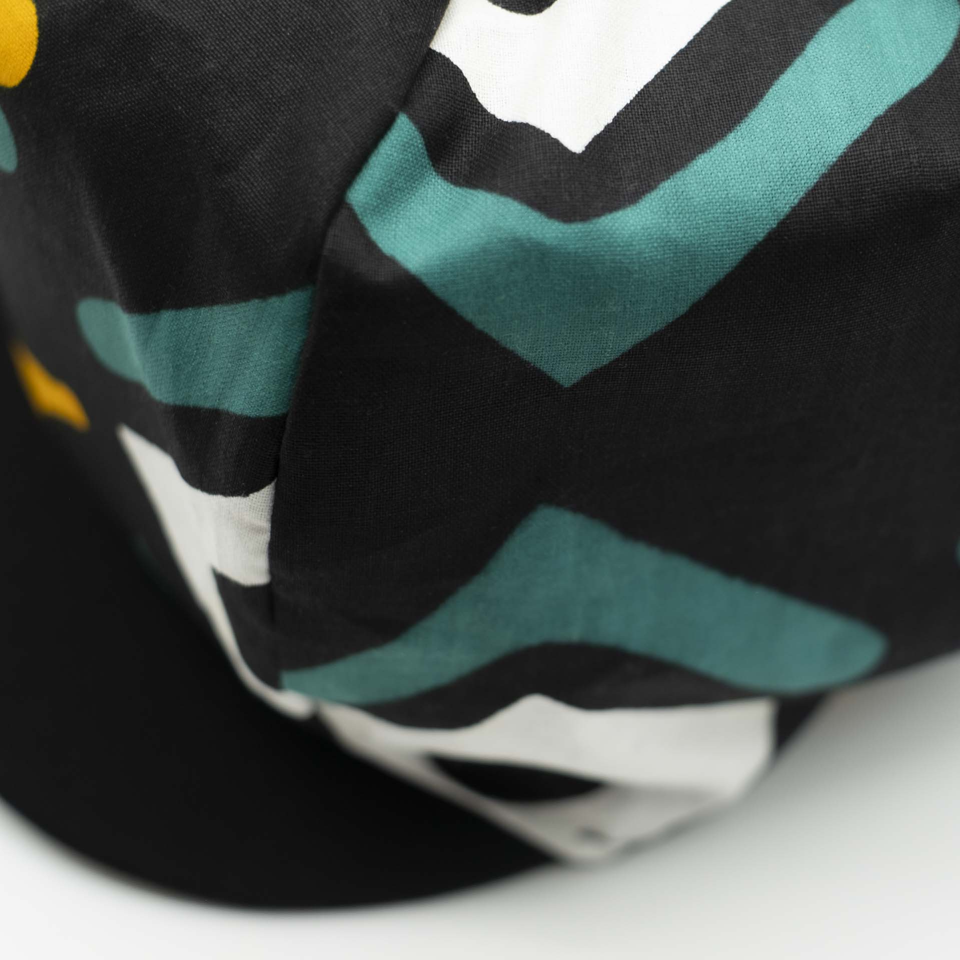 Casquette Rasta gavroche dreadlocks avec visière en tissu léger wax aux motifs ethnique blanc jaune et vert sur fond noir doublure noir