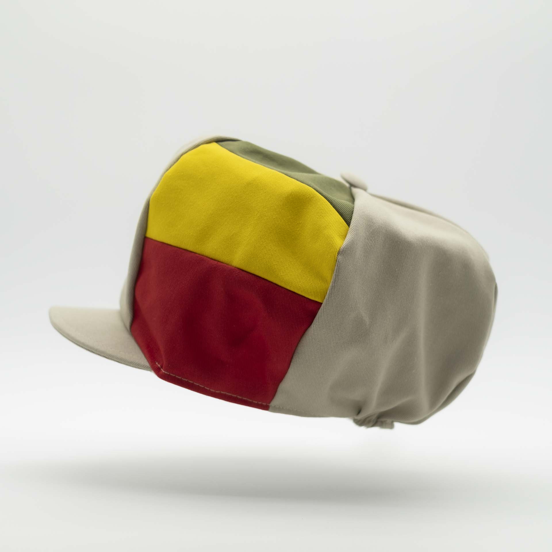 Rasta cap with visor for dreadlocks in beige cotton with three green yellow red stripes on one side of the hat and ecru lining