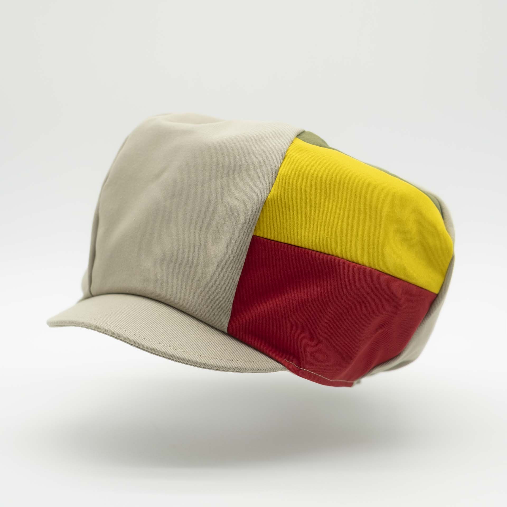 Rasta cap with visor for dreadlocks in beige cotton with three green yellow red stripes on one side of the hat and ecru lining