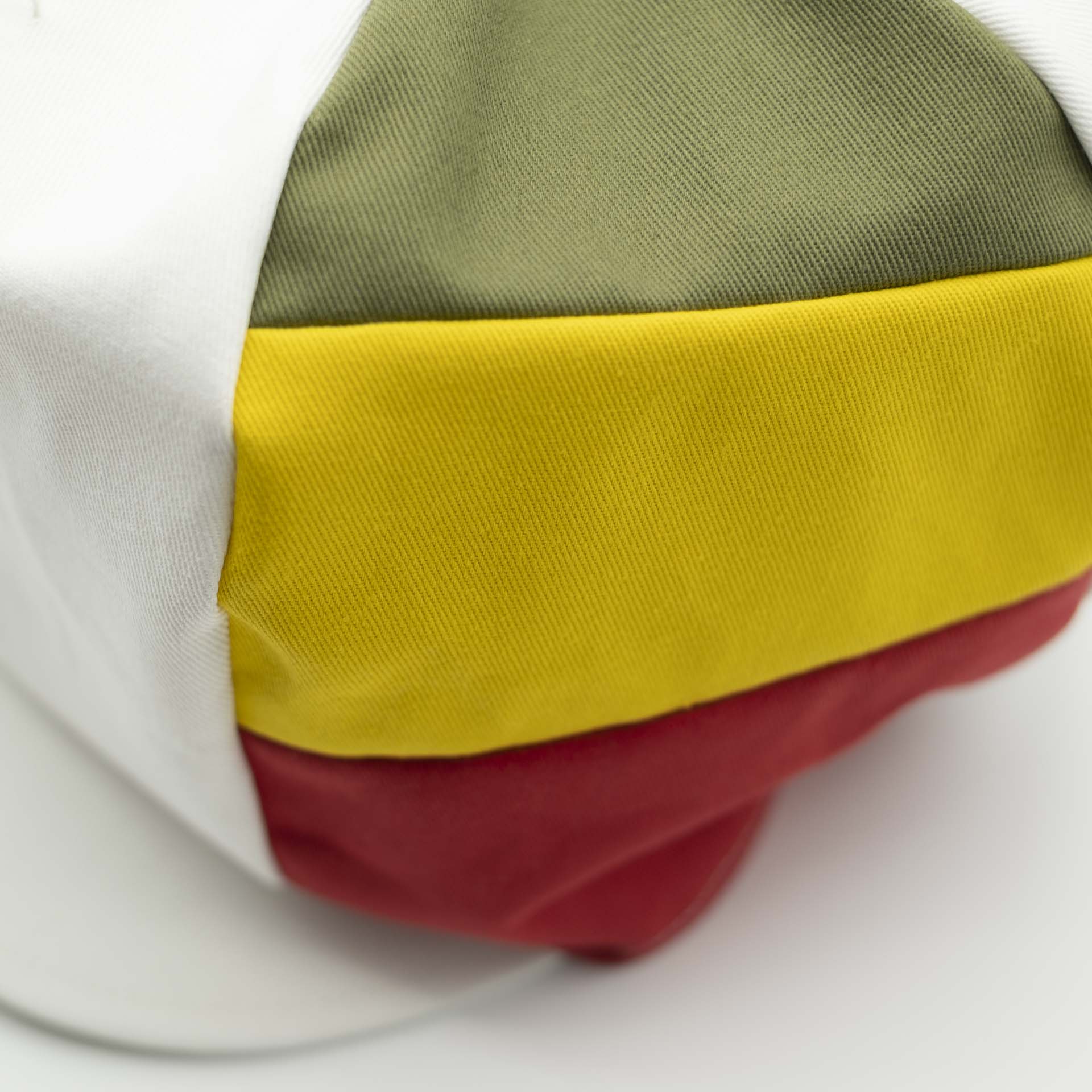 Casquette Rasta avec visière pour dreadlocks en coton blanc avec trois bandes vert jaune rouge sur un côté du chapeau et doublure blanc