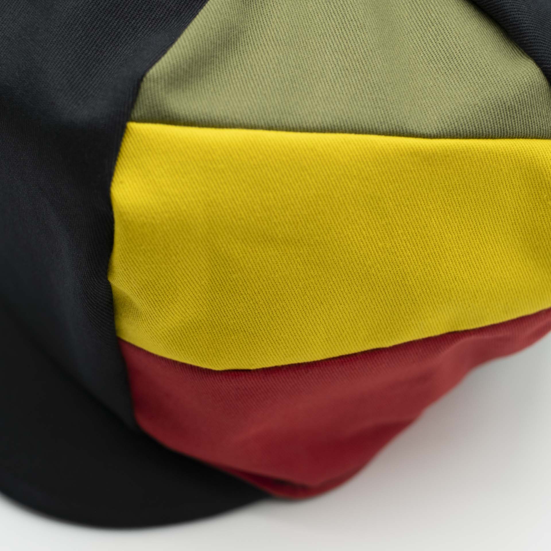 Rasta cap with visor for dreadlocks in black cotton with three stripes green yellow red on one side of the hat and black lining