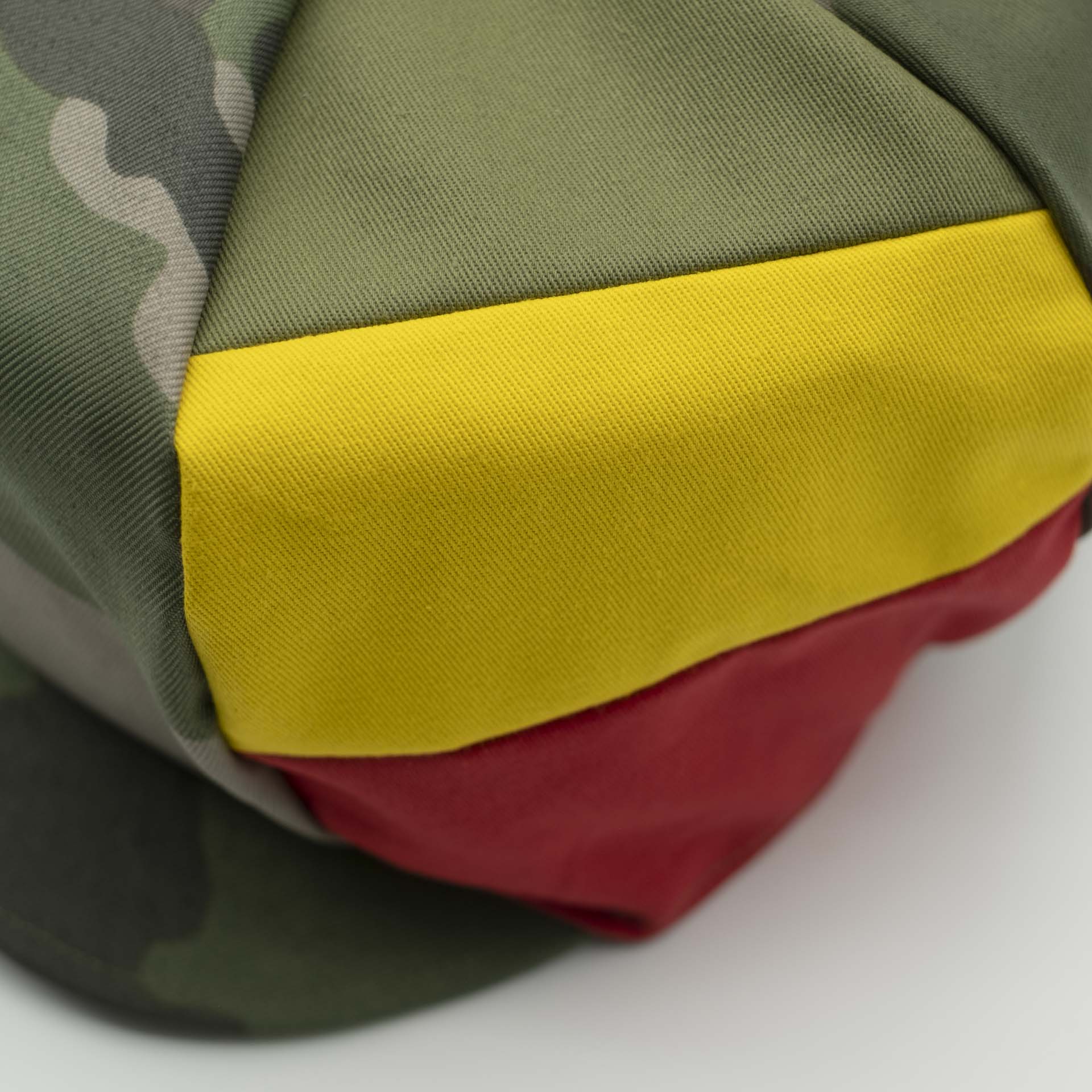 Casquette Rasta avec visière pour dreadlocks en camouflage militaire avec trois bandes vert jaune rouge sur un côté du chapeau et doublure noir