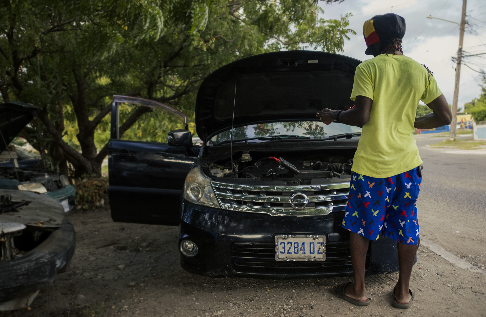 Rastaman fixing a car in Kingston with a dreadlocks hat from the Rocksteady collection