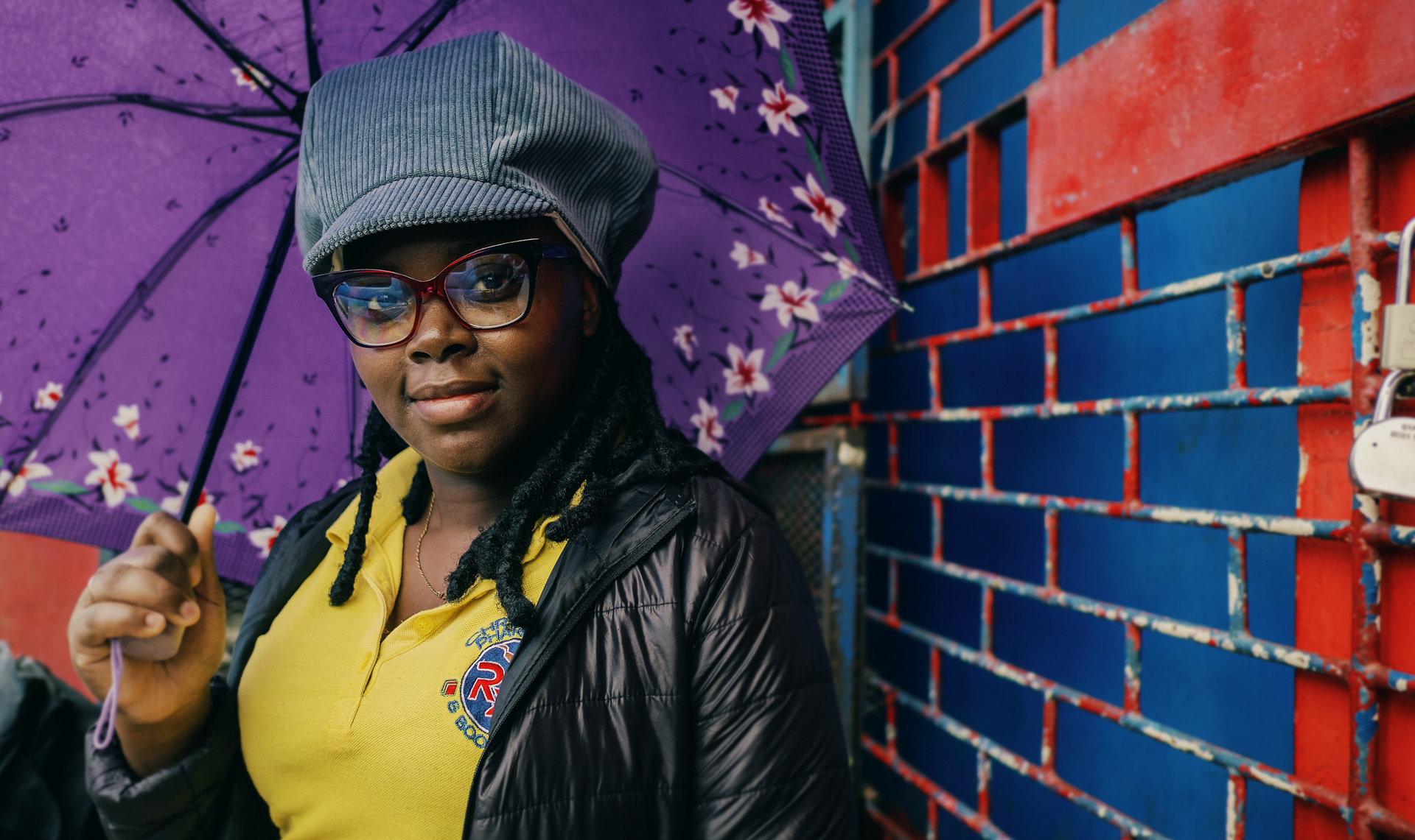 A pretty lady posing for Dreadlocks Nation with a blue corduroy rasta hat