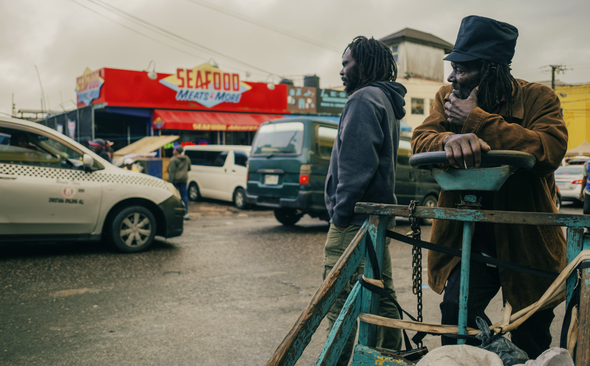 Jamaican Rasta driving his pushcar in the street with a pure black dreadlocks hat crown