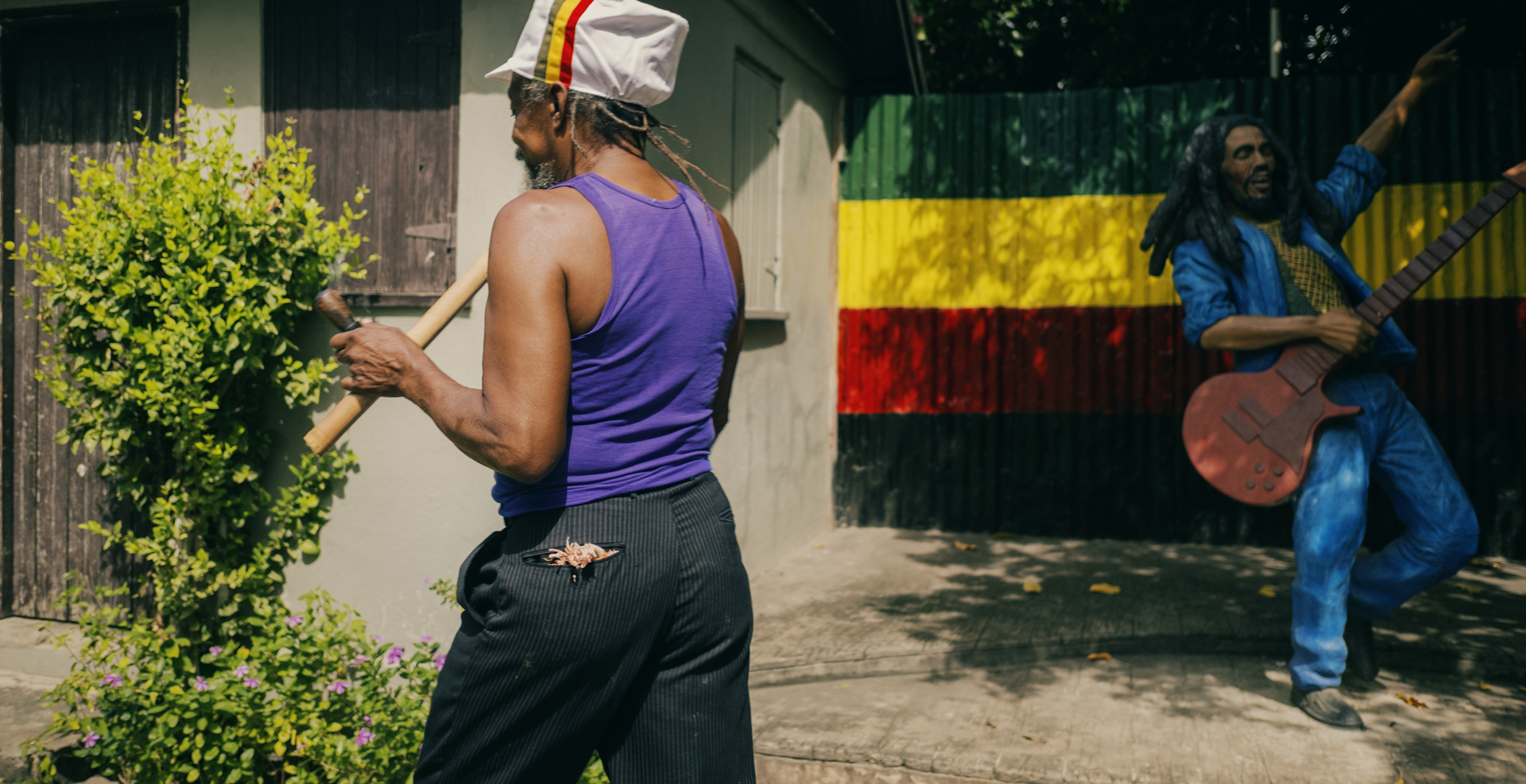 At cultural yard a rastaman with a white rasta cap