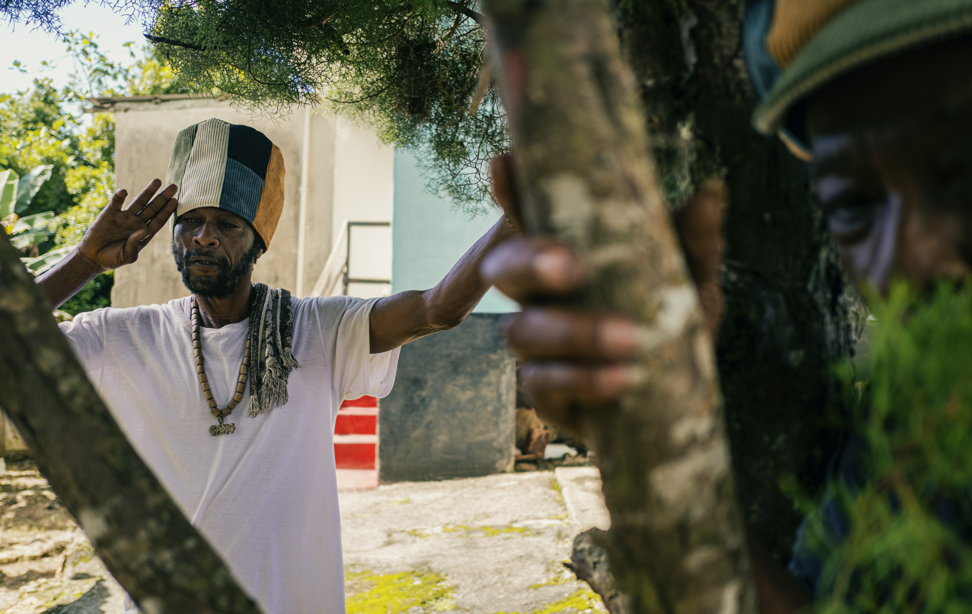 Portrait of a Jamaican militant in his yard with a corduroy Dreadlocks hat