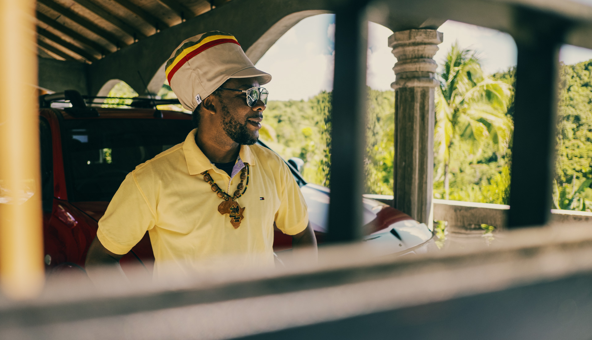 Patrique devant sa maison en Jamaique avec une casquette pour dreadlocks beige