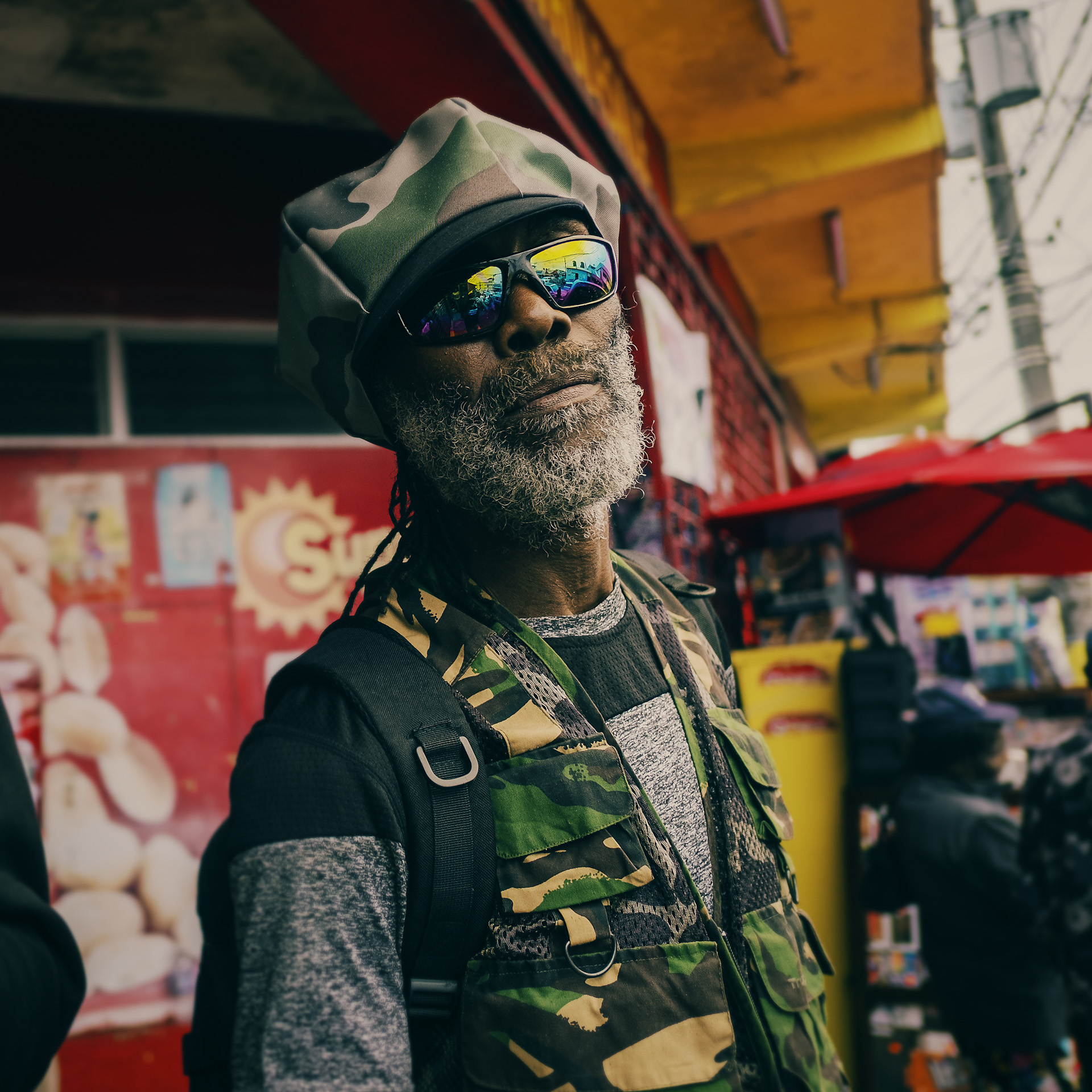 Rasta qui pose dans la rue avec une chapeau militaire à visière