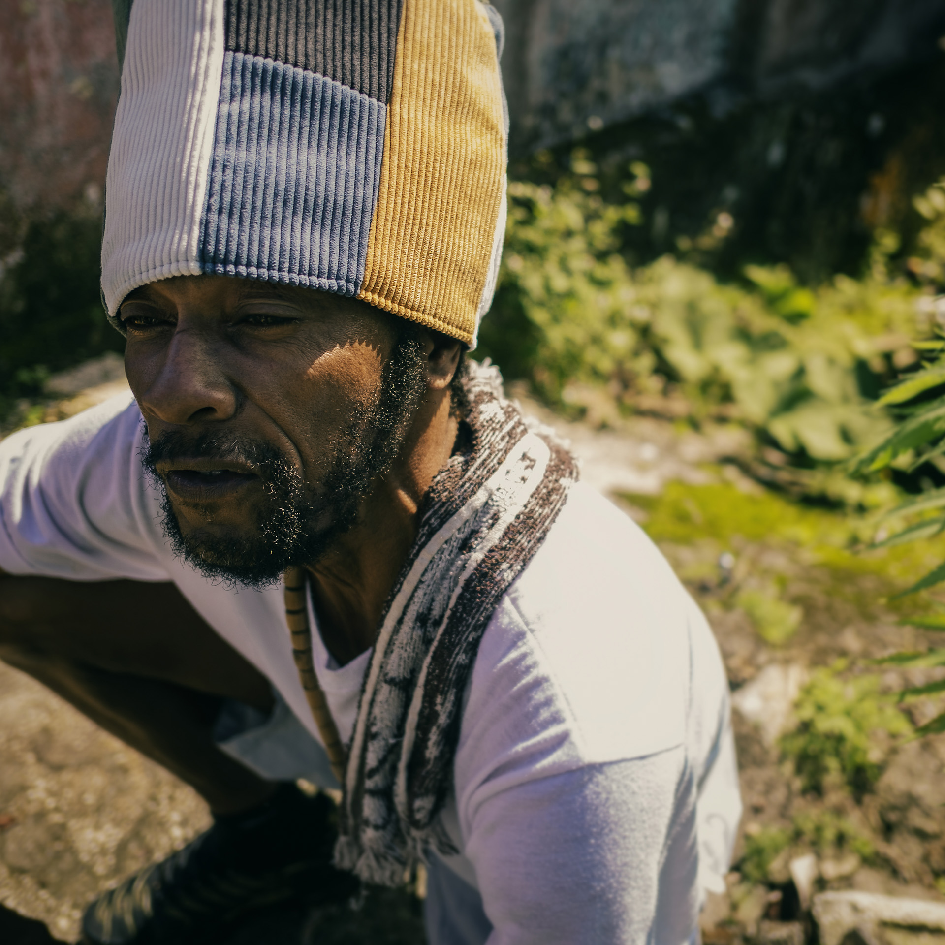 Portrait of a Jamaican in his yard with a corduroy Dreadlocks hat