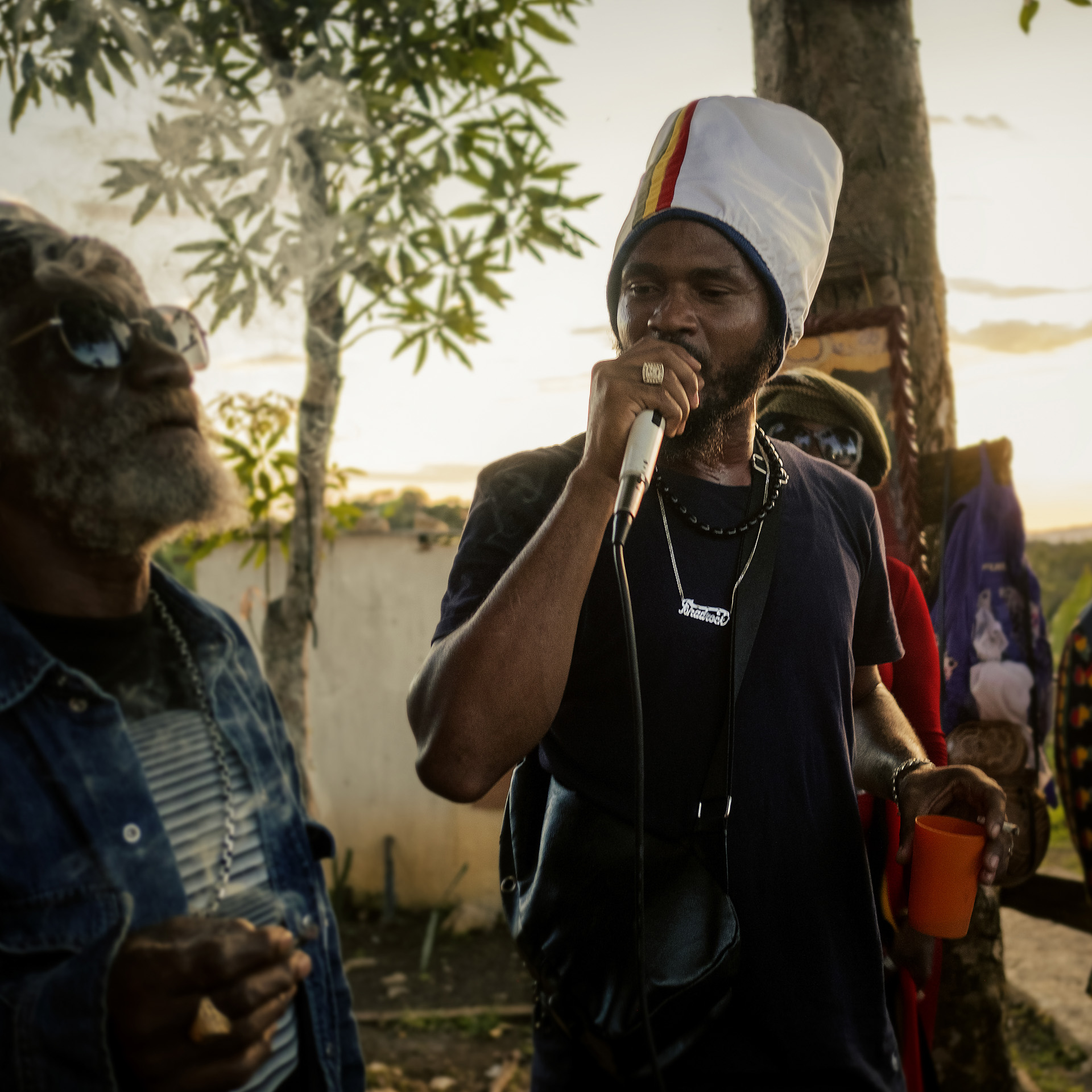 Ishadrock Jamaican artist performing in the middle of the hills with a big with dreadlocks hat striped with Ethiopian colors